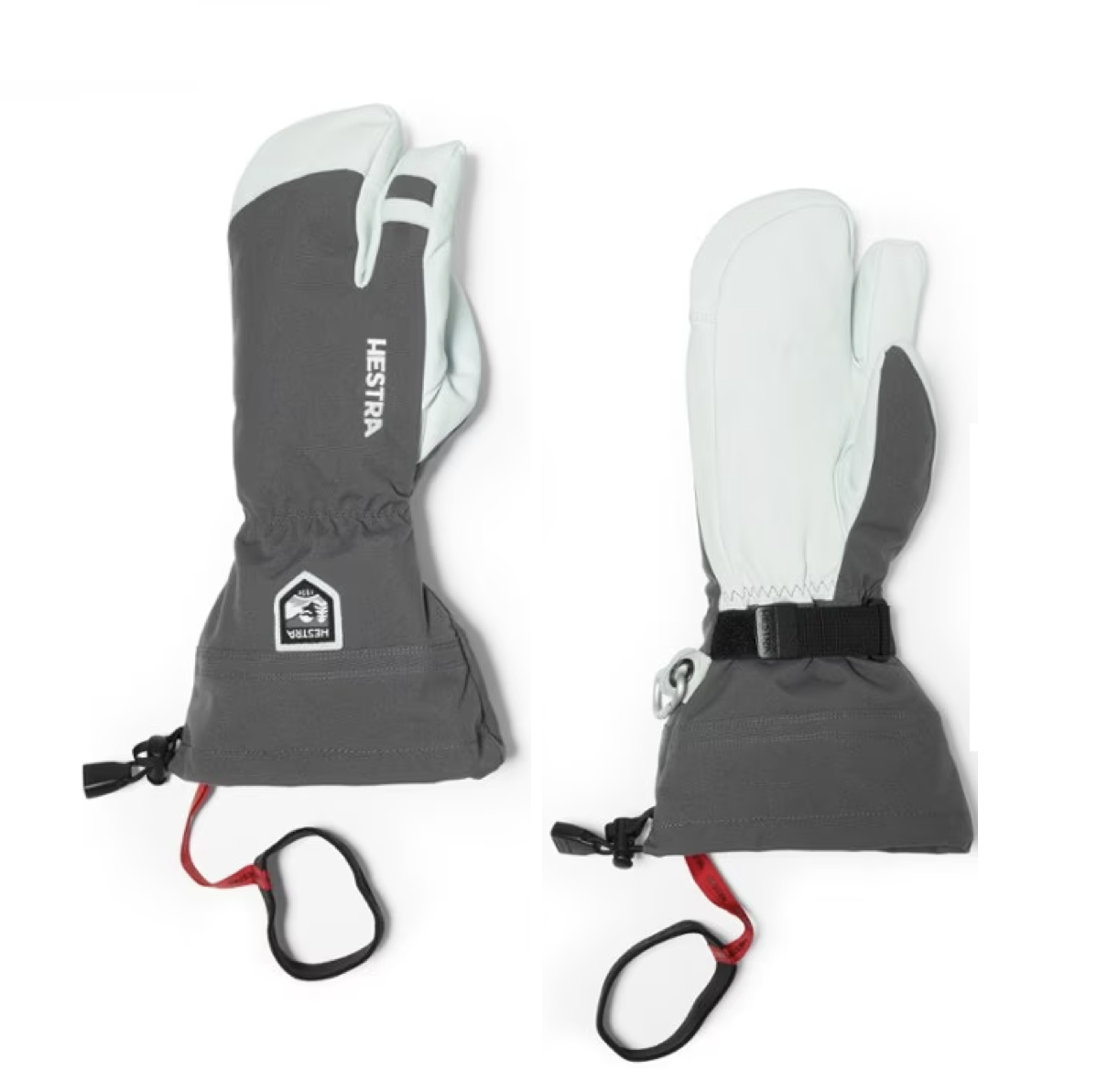 Pair of Hestra ski gloves, black and white with adjustable wrist straps and red loops for attachment.