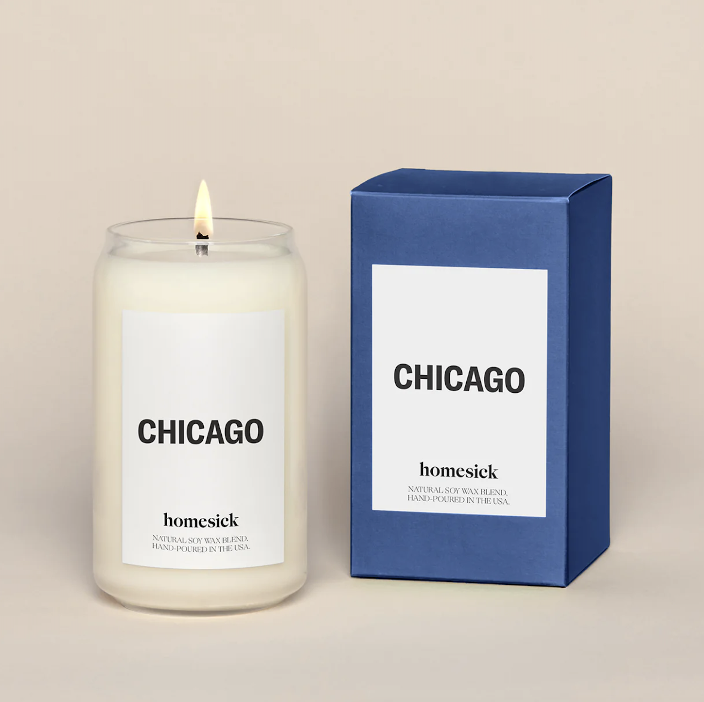Cream-colored candle with flame beside a blue box, both labeled 'CHICAGO' and 'homesick' for a soy wax candle.