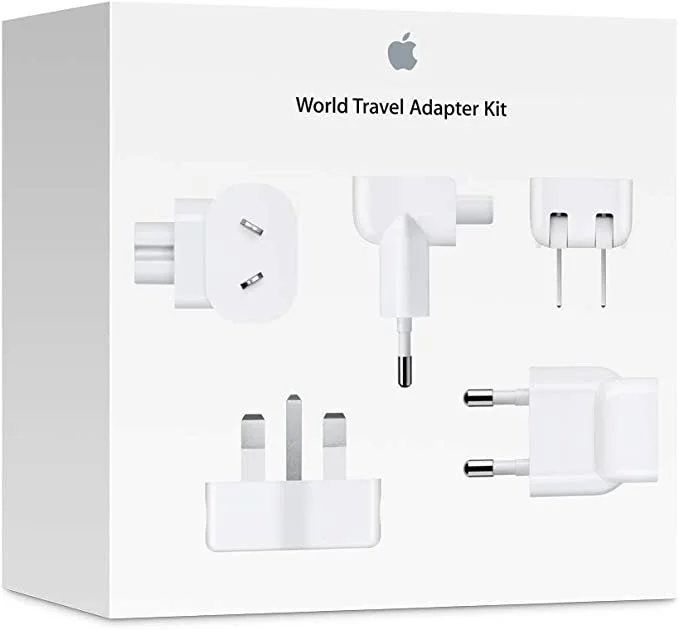 Box containing a world travel adapter kit with multiple plug adapters, a USB power adapter, a power cord, and a USB-C charging cable.