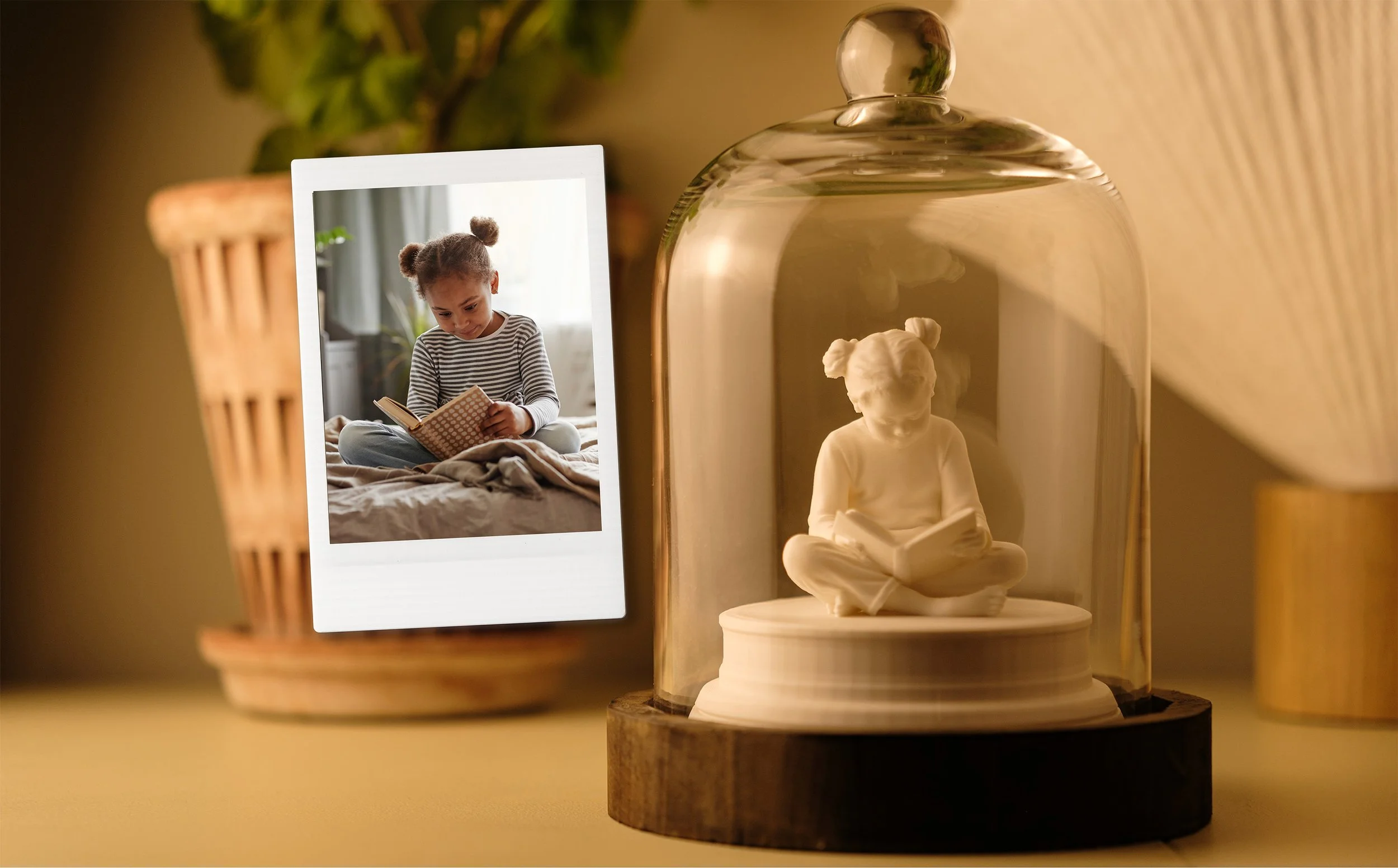 En prydnadsfigur av en liten flicka som sitter och läser bok, placerad under en glaskupa.
