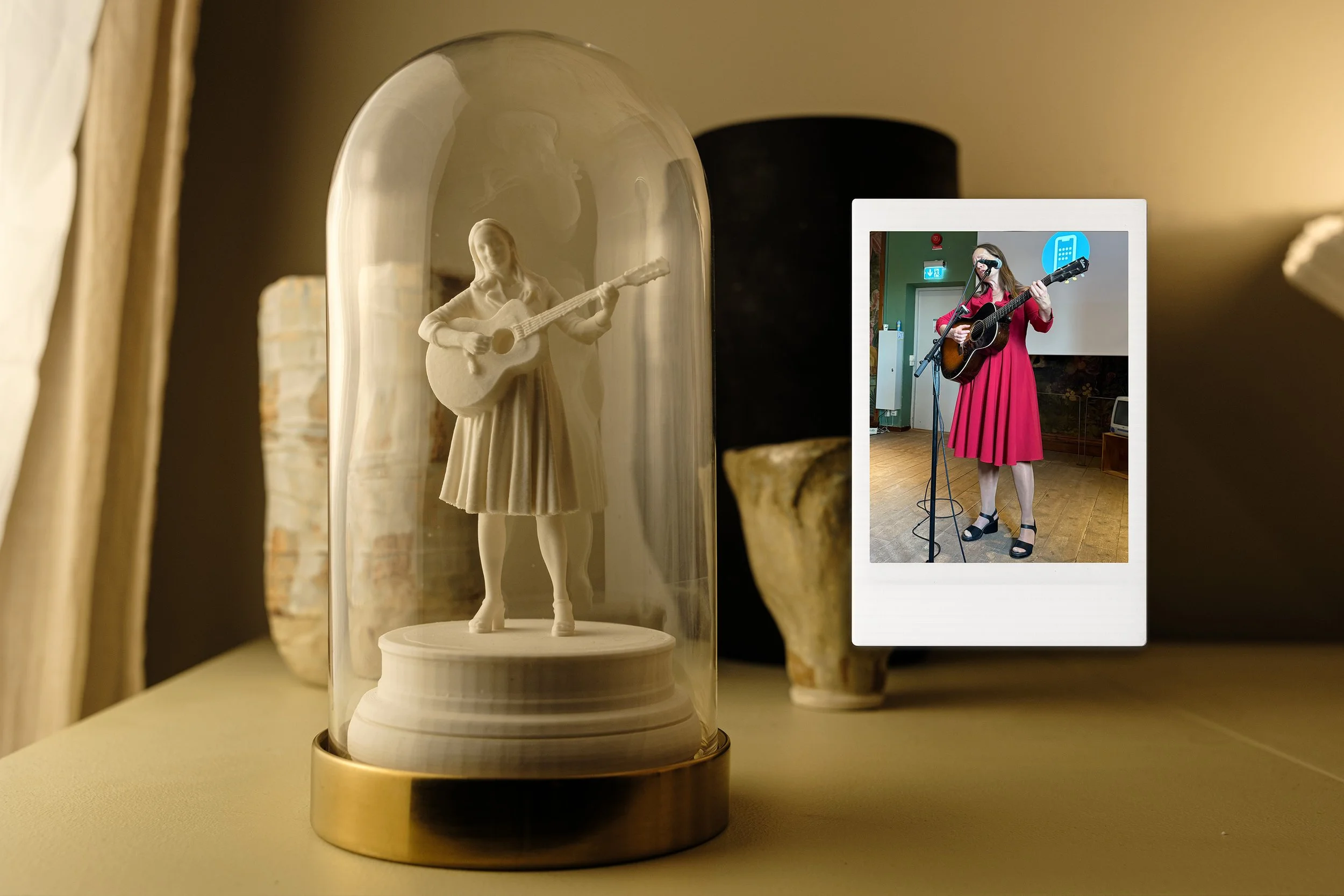 En figurin under en glakupol föreställande en kvinna som spelar gitarr.