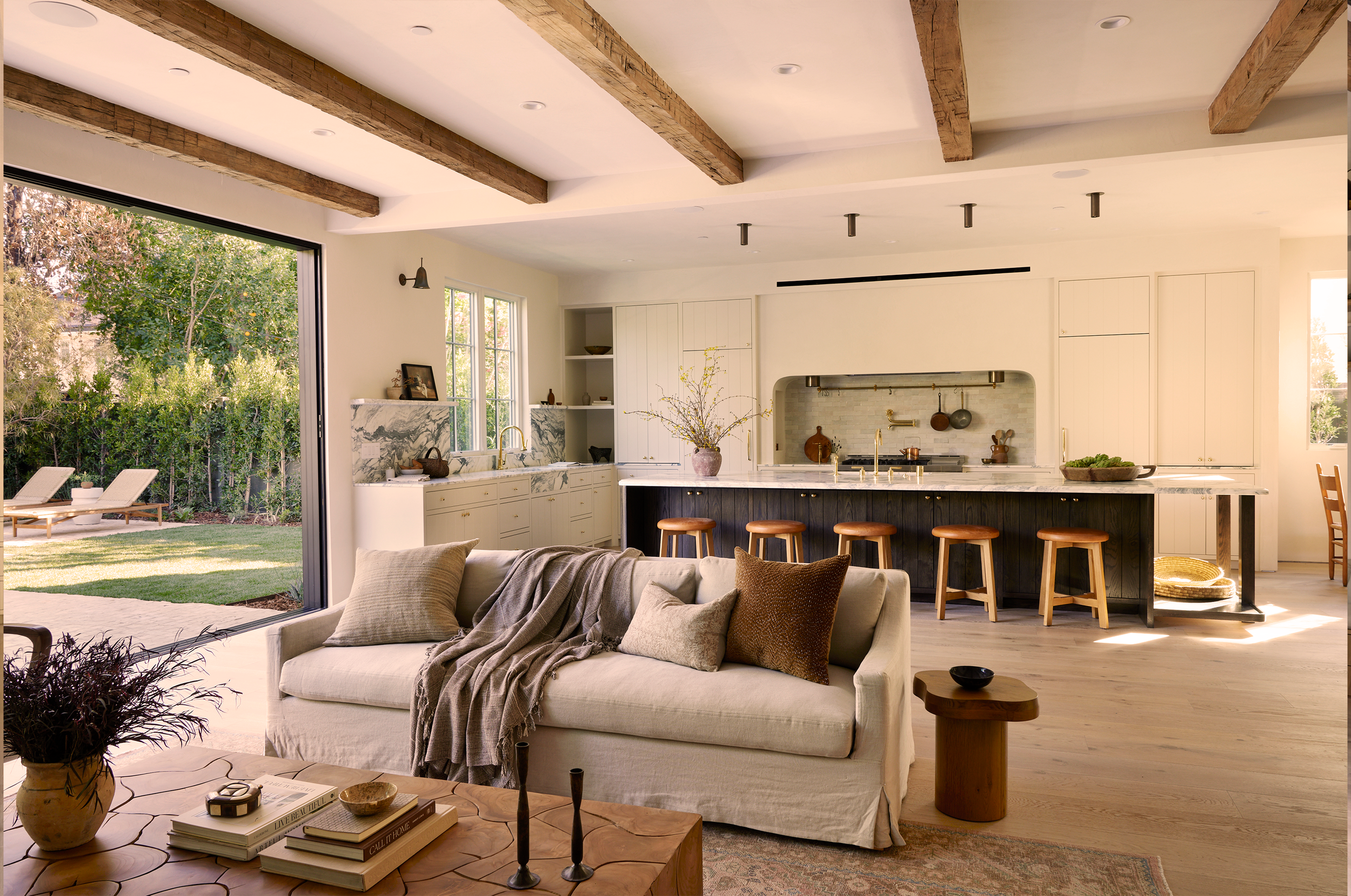 4338 Rhodes Ave, Studio City. Open concept living room and kitchen with large sliding glass door leading to outdoor patio, natural light, neutral decor, wood accents, and modern furniture.