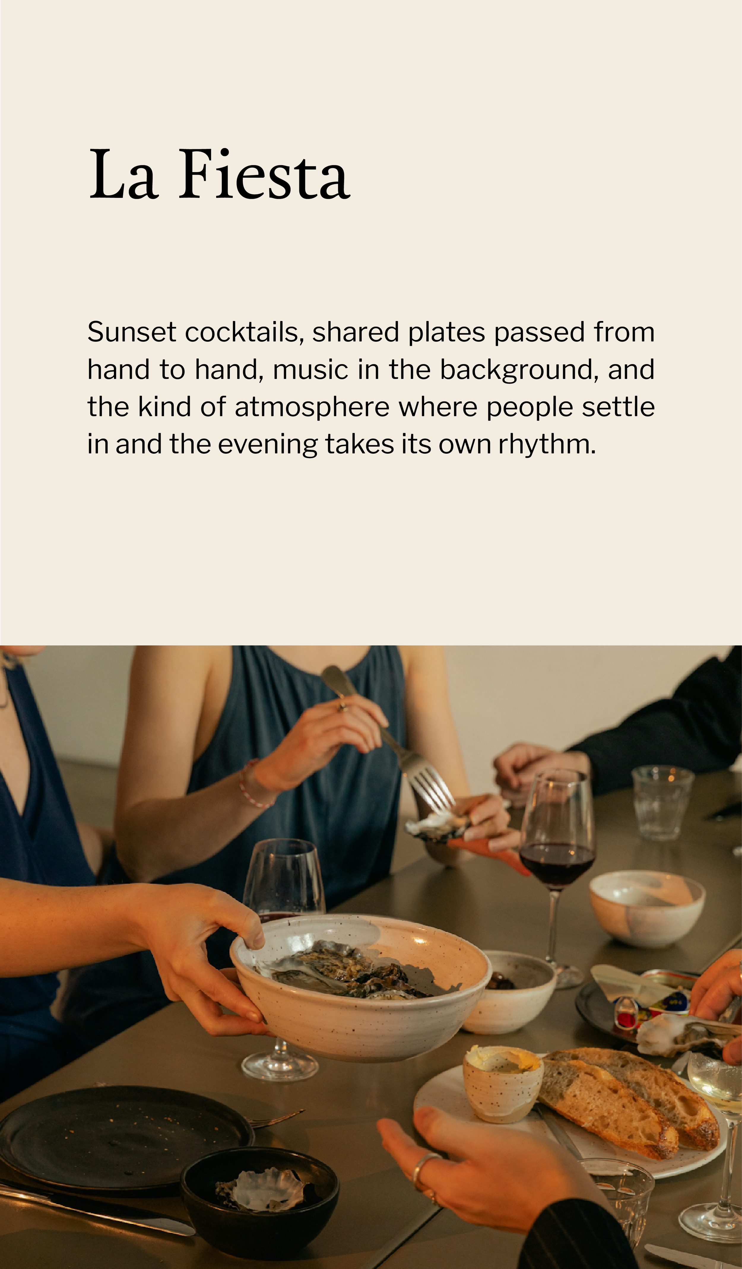 A group of people sitting at a dinner table sharing a meal, with dishes including oysters, bread, and glasses of wine.