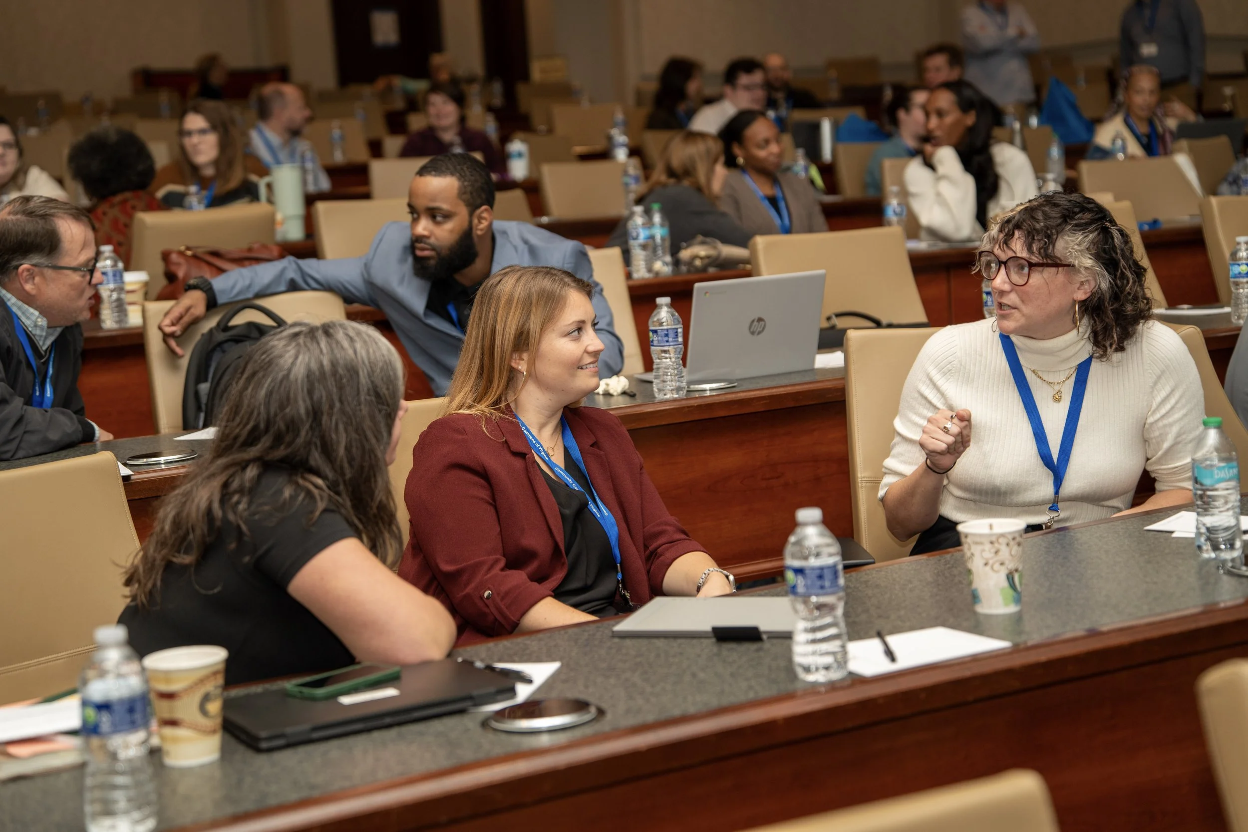 Conference attendees engaged in conversation in a lecture hall