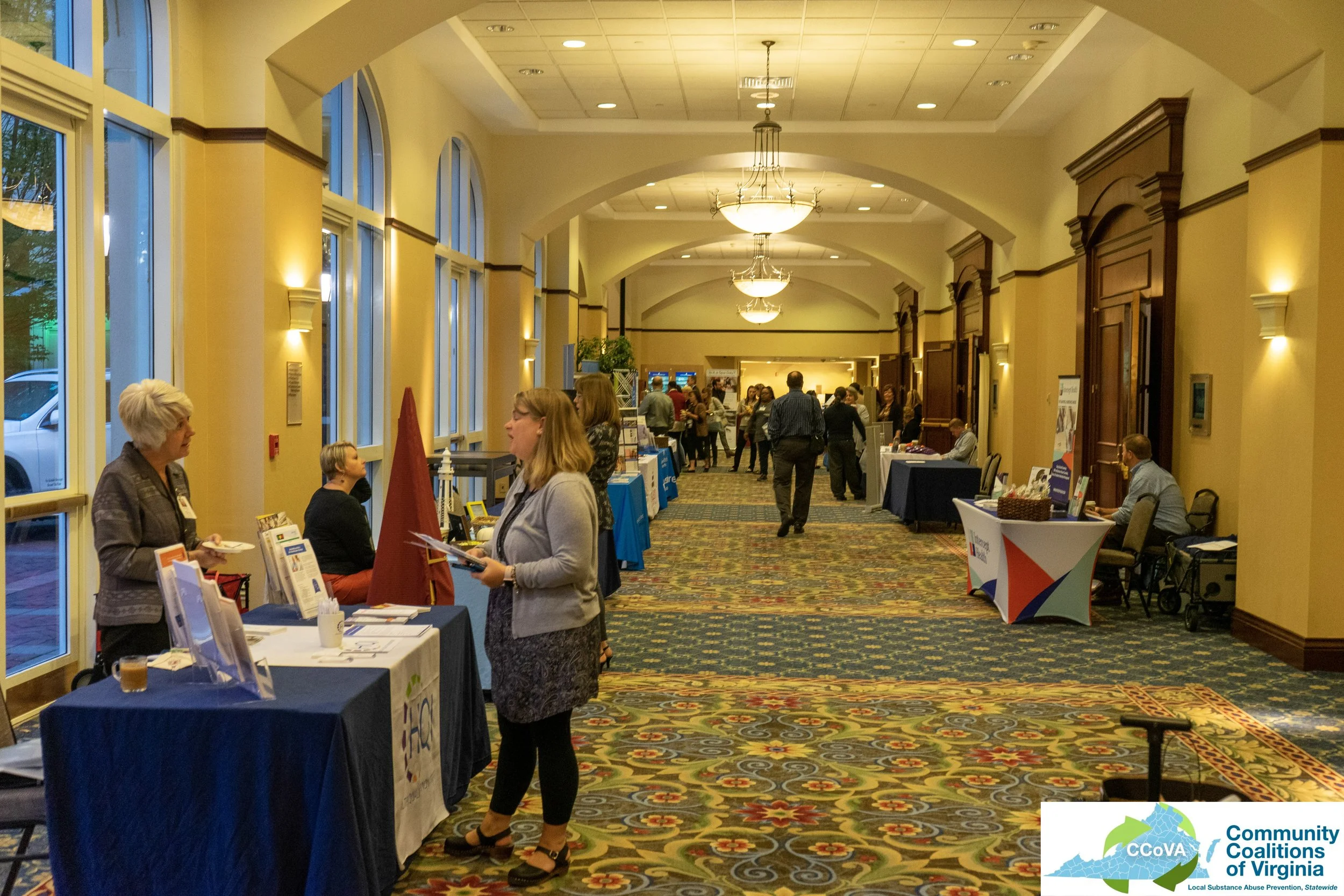 Conference attendees and exhibitors engaged in conversation in main hall