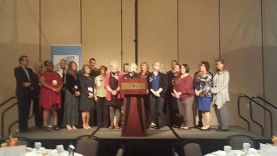 Group photo behind lectern in conference room