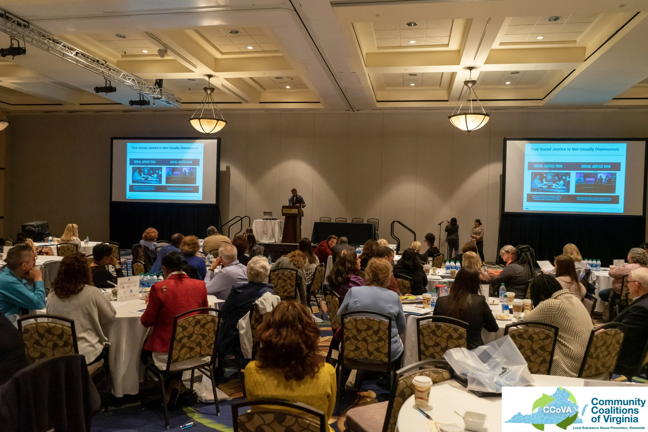 Conference attendees in main ballroom watching a presentation