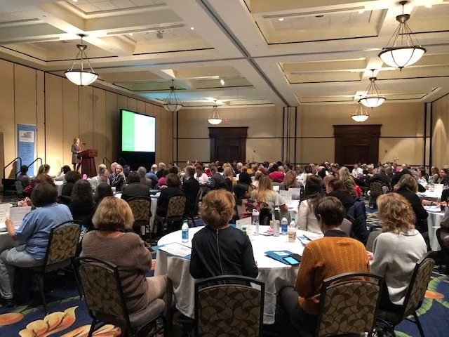 Ballroom full of conference attendees viewing a presentation