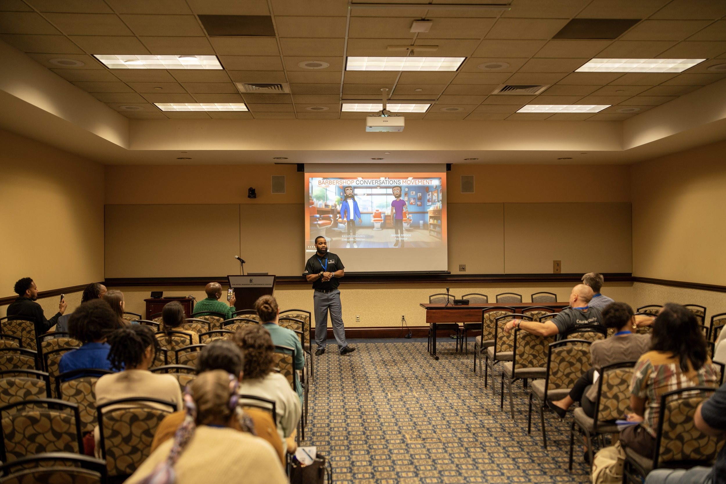 Room of conference attendees watching a presentation