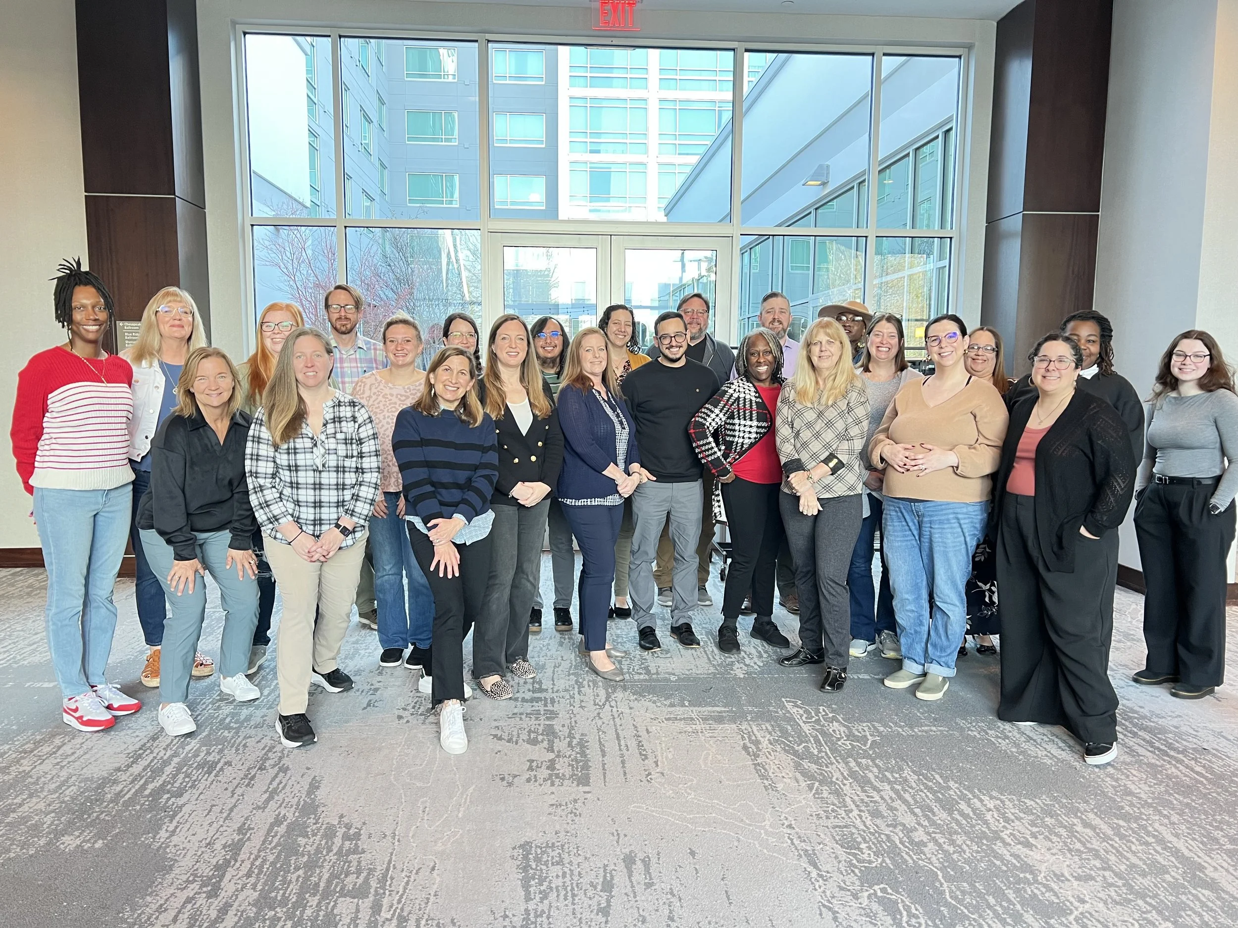 Members of 2025 Mini Academy training posing as a group with instructor Dorothy Chaney in a conference center