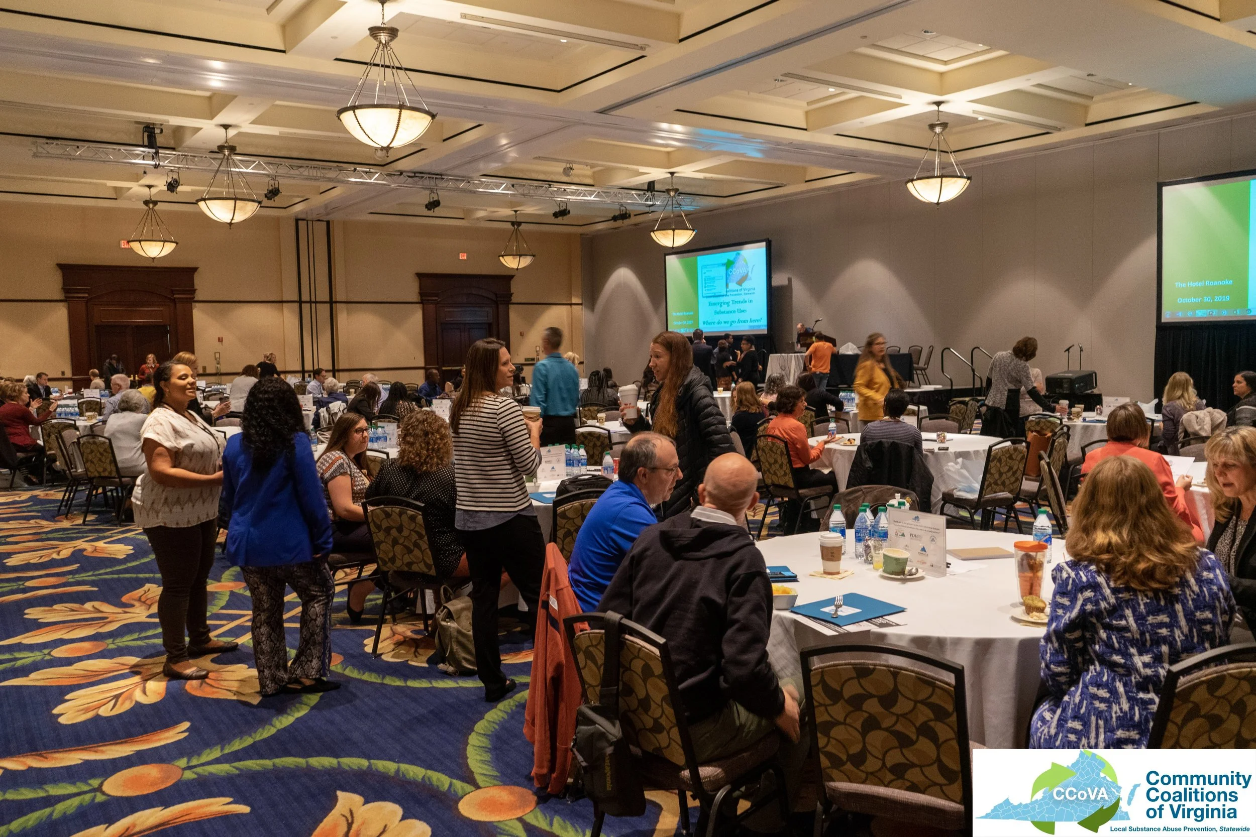 Room full of conference attendees socializing between sessions