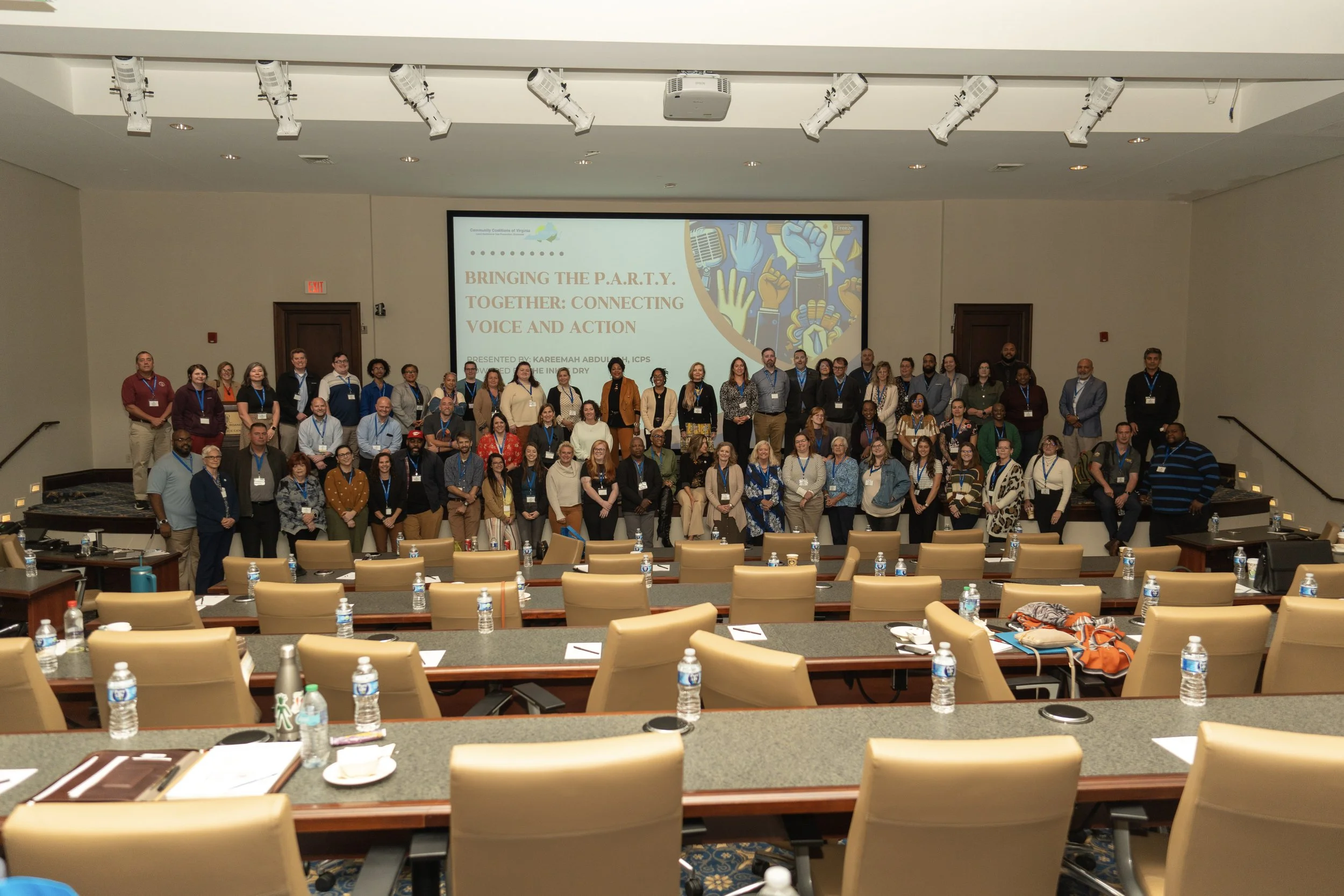 Group photo of conference attendees posing at the front of a lecture hall