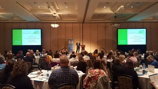 Ballroom full of attendees viewing a presentation