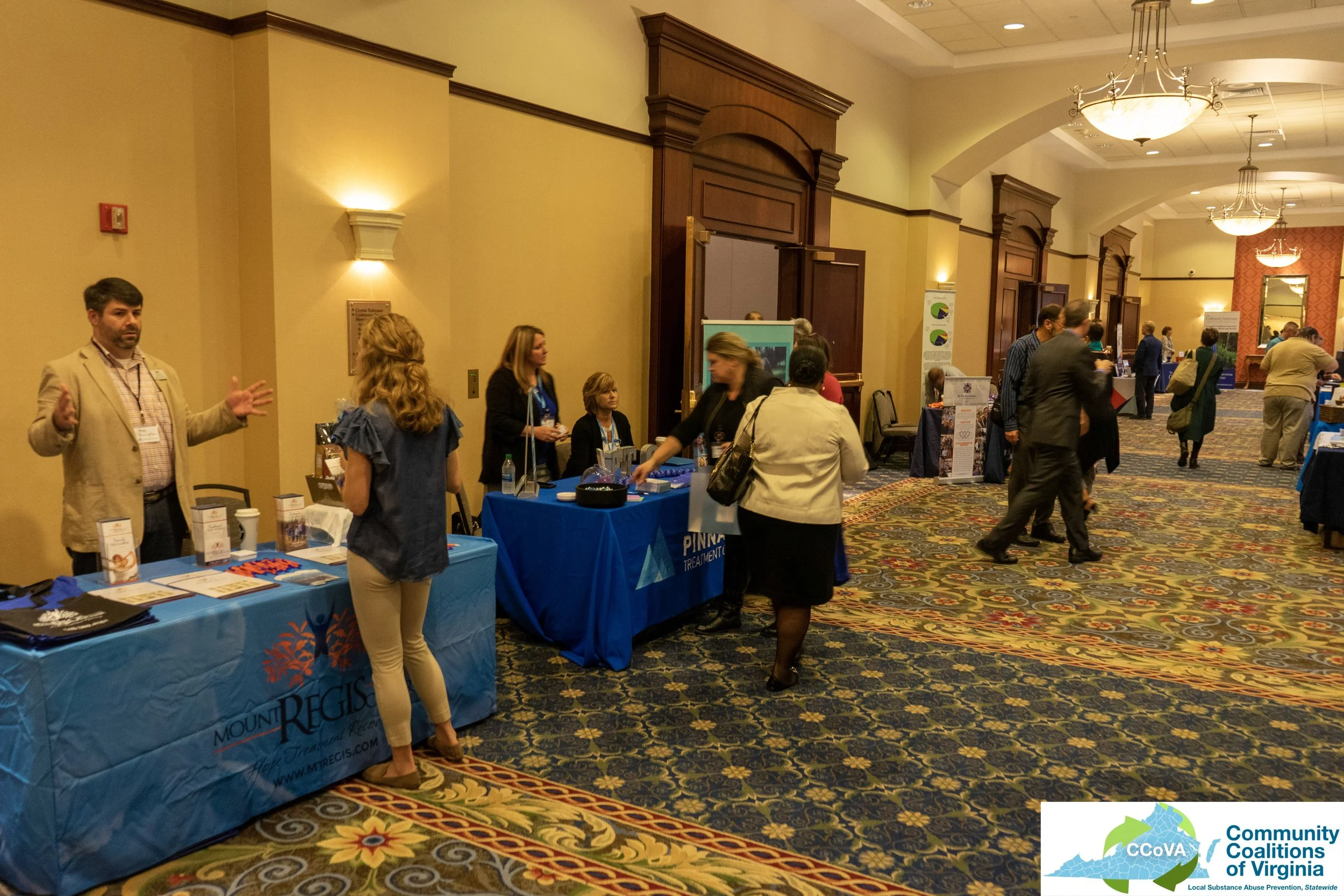 Conference attendees and exhibitors engaged in conversation in main hall