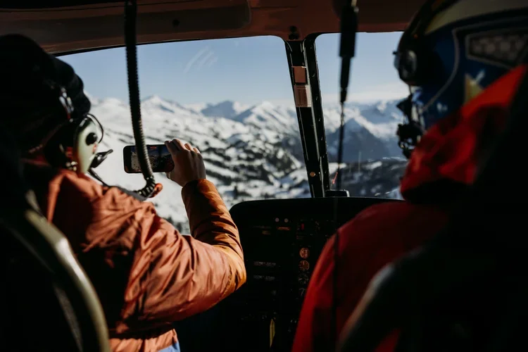 Passenger taking photos of winter alpine scenery.