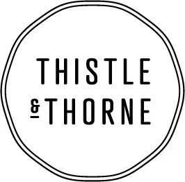 Logo with the text 'Thistle & Thorne' inside a double circle outline.