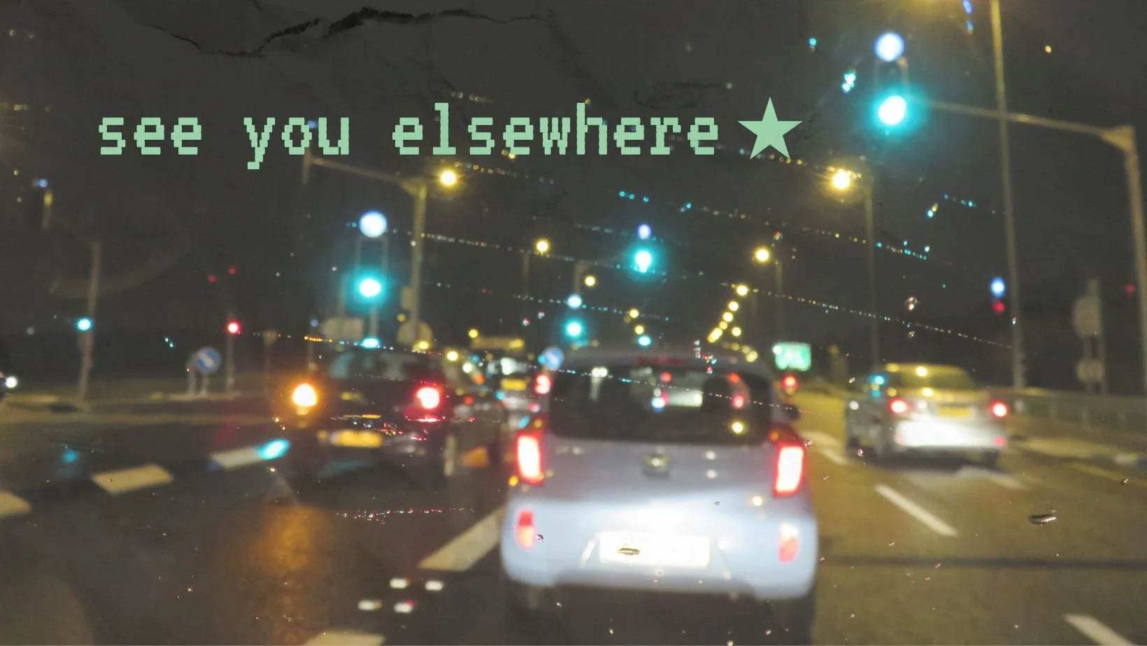 Blurry nighttime city traffic viewed through a car windshield with “see you elsewhere” text overlay.