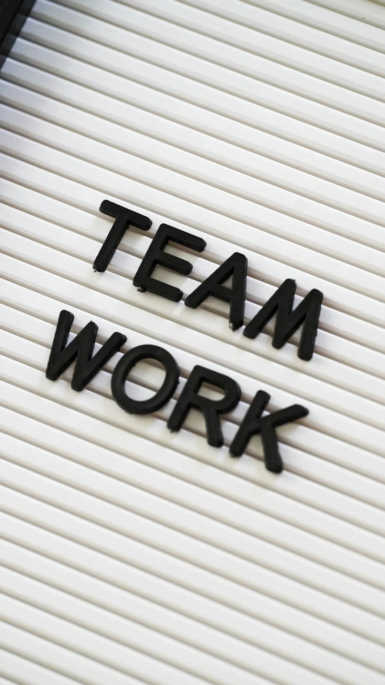Letter board with the words "TEAM WORK" in black letters.