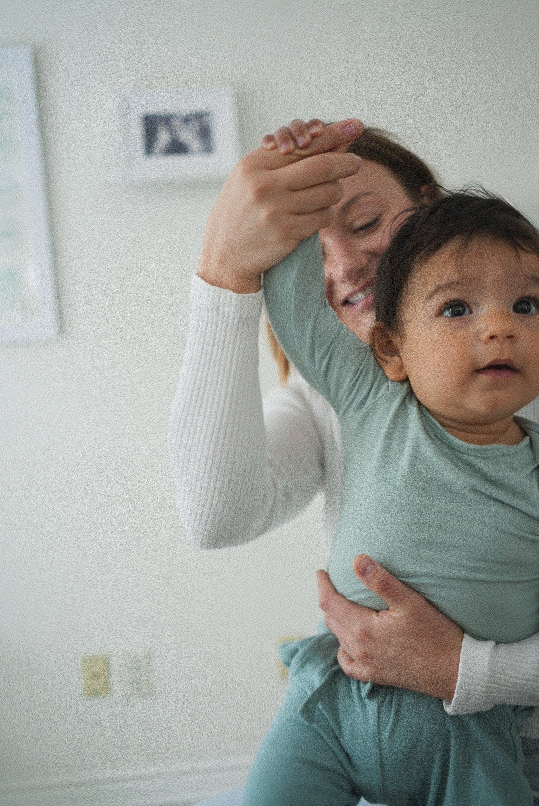 Dr. Madison Smith, birth & postpartum doula at Intuitive Heart, plays with a baby while performing a chiropractic adjustment on it.
