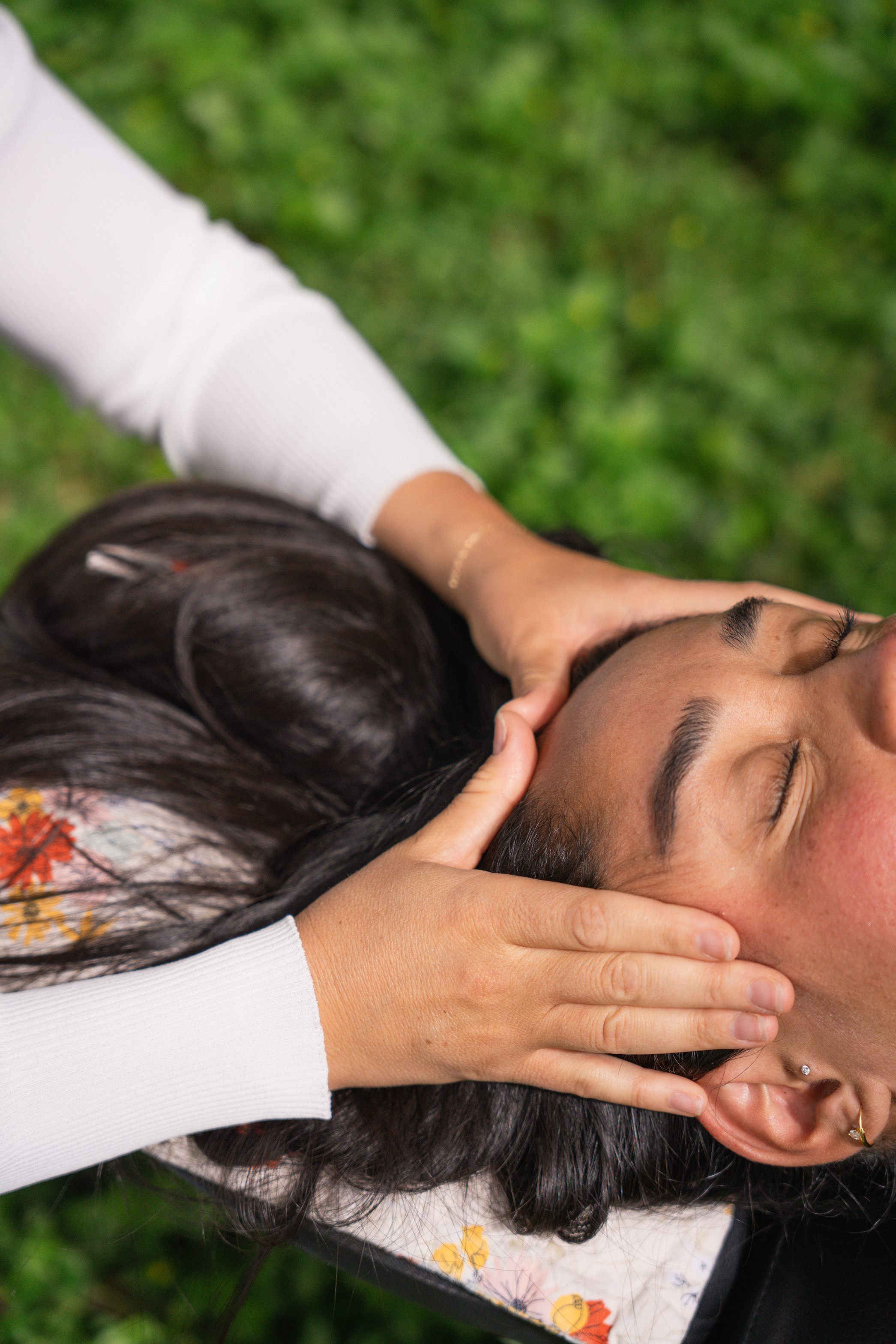 Dr. Madison Smith, chiropractor at Intuitive Heart, places her hands on either side of a clients head while giving an adjustment.