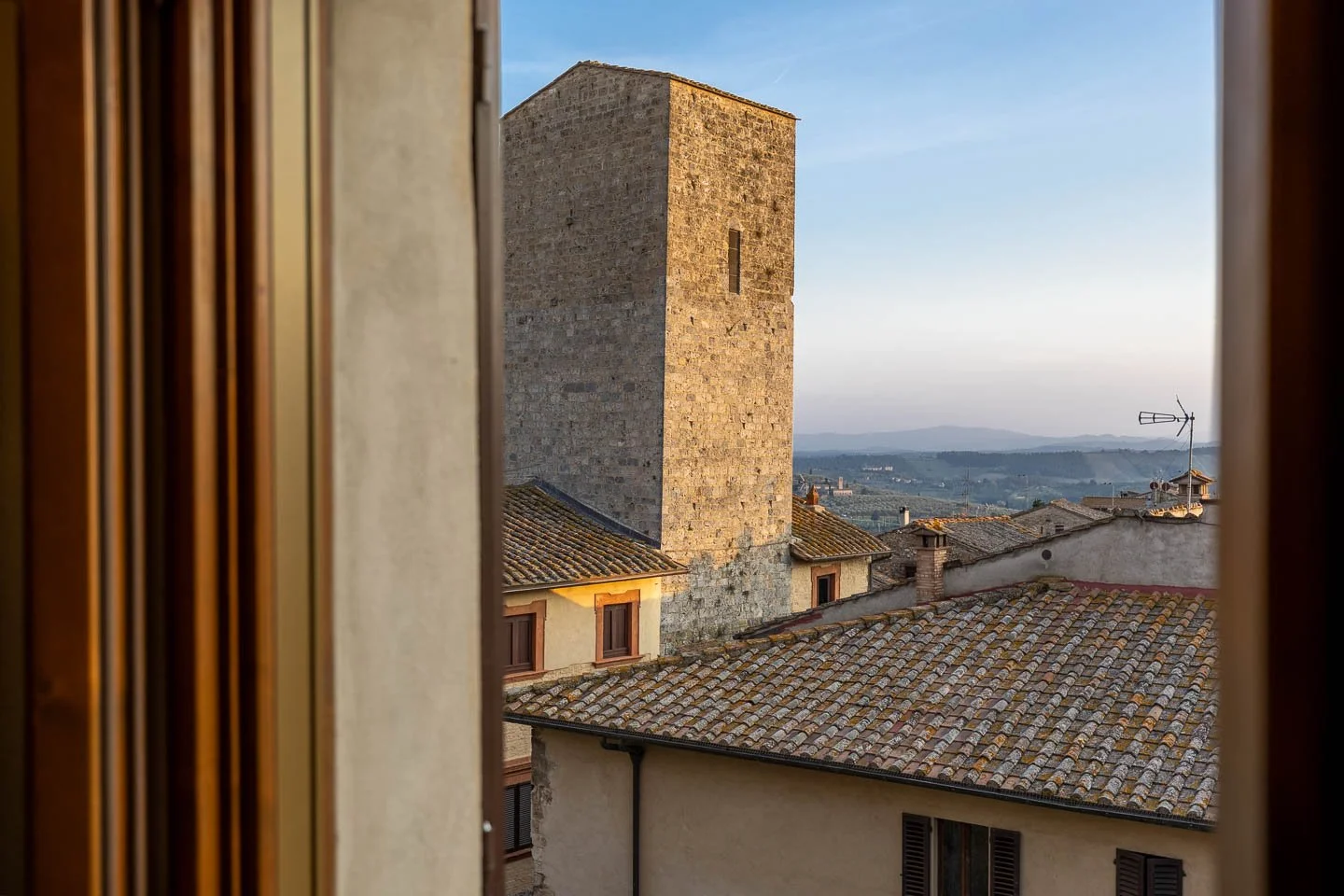 Rooftop and tower view at sunset from a luxury holiday apartment in San Gimignano old town, Tuscany