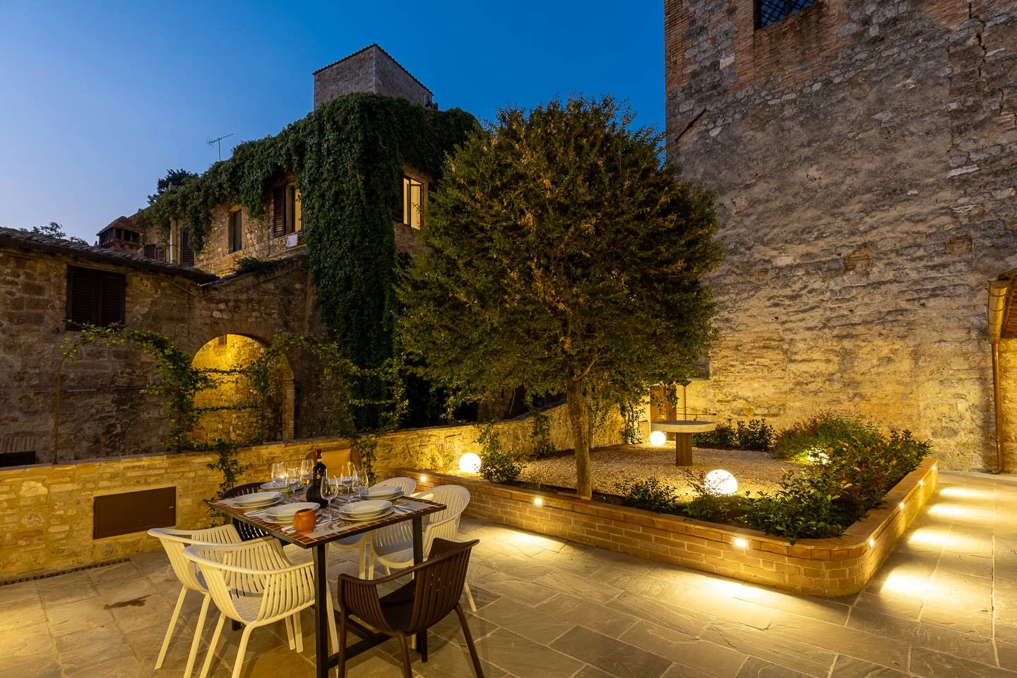 Night view of the private courtyard patio in a premium holiday apartment in the historic center of San Gimignano