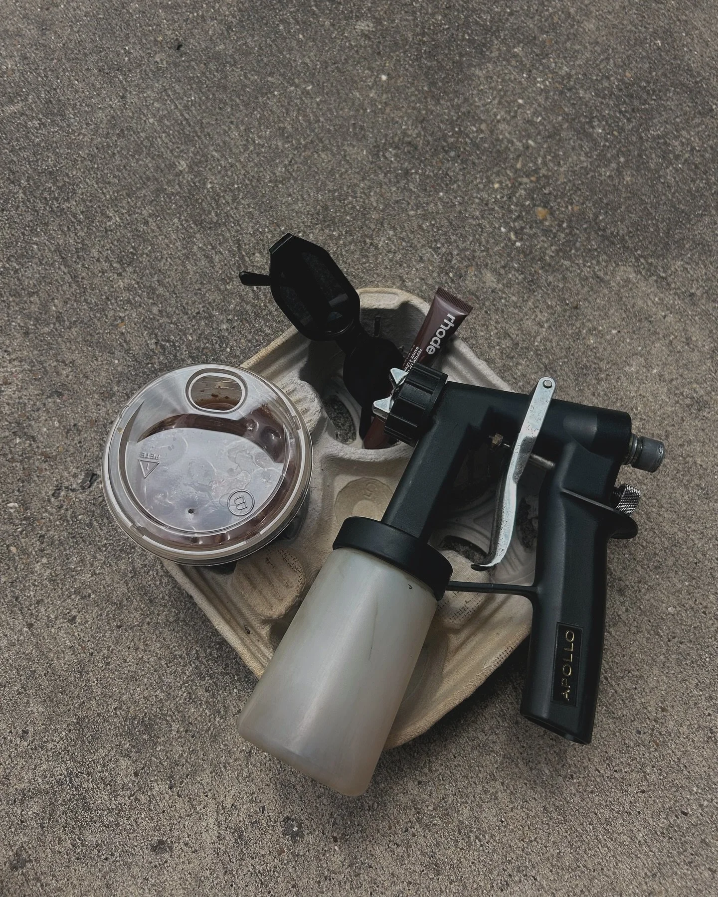Image of a spray tan gun and iced coffee