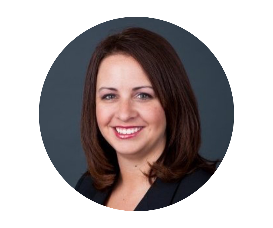 Headshot of a woman with shoulder-length brown hair, smiling, wearing a black blazer against a dark blue background.