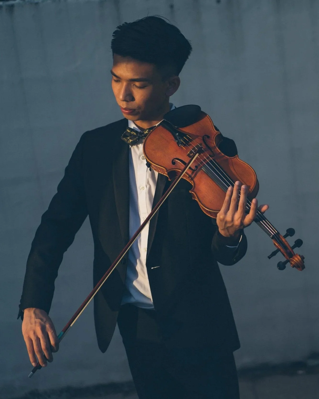 Asian violinist playing violin.
