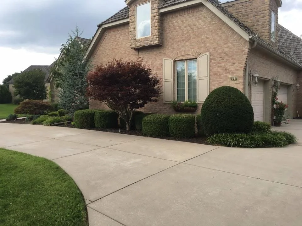 Front view of a brick house with a landscaped yard and driveway.