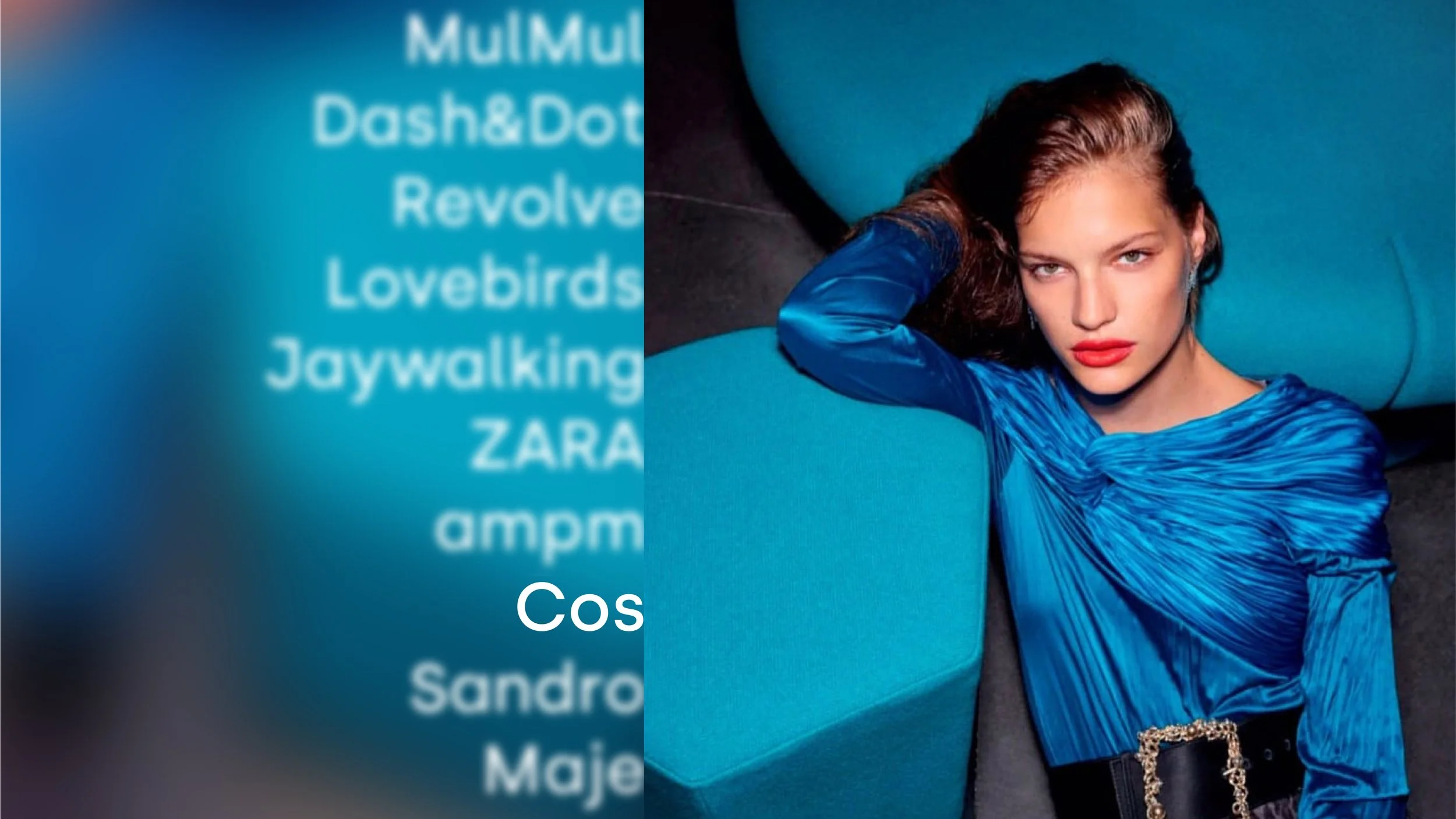 A woman with fair skin and red lipstick lying on her back on a dark surface, resting her head on a large, blue, bean-shaped cushion. She is wearing a shiny, long-sleeved, blue top and has her right hand behind her head, looking directly at the camera.