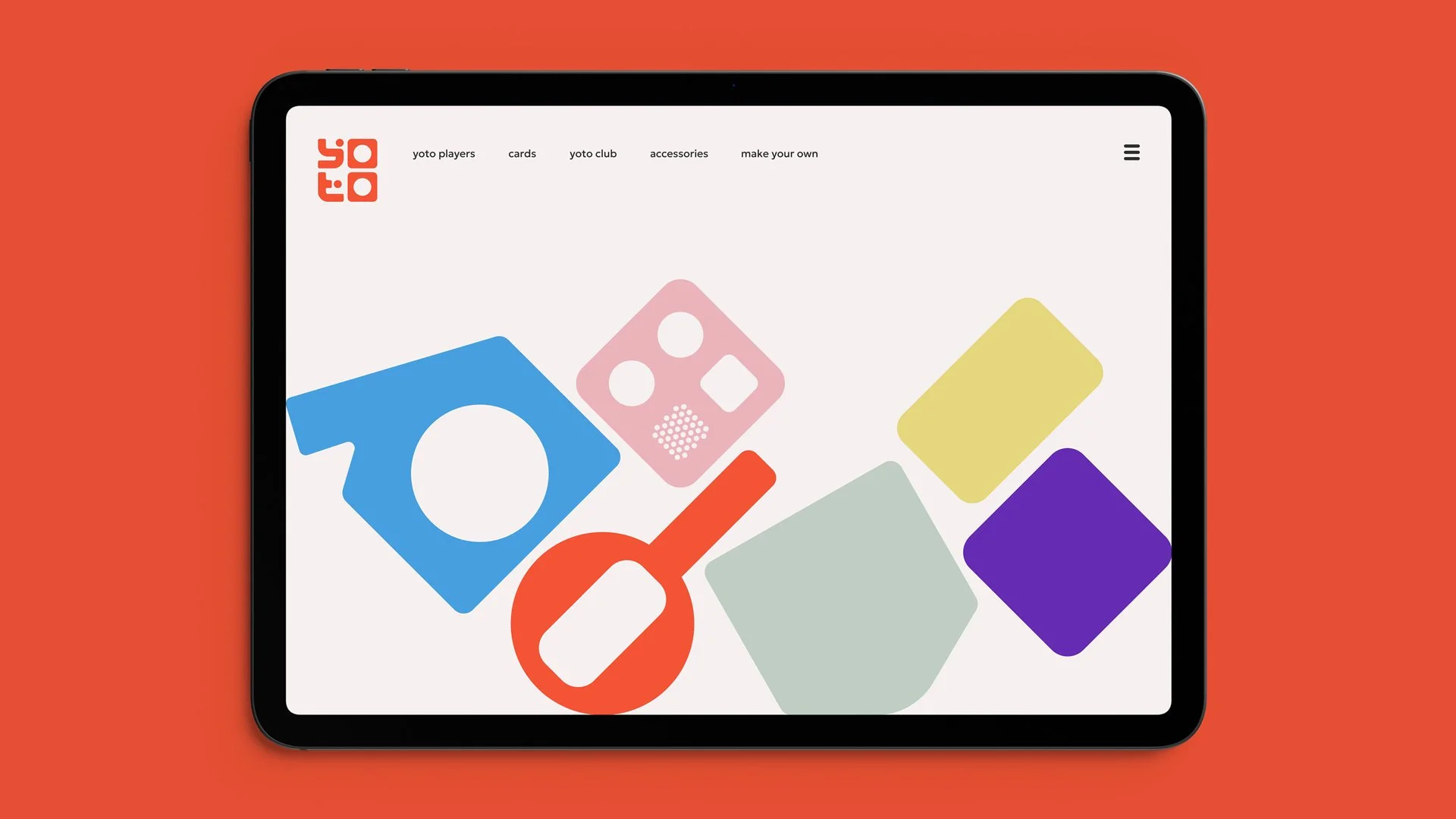 Tablet displaying the Yoto website with colorful toy shapes on the screen, set against an orange background.