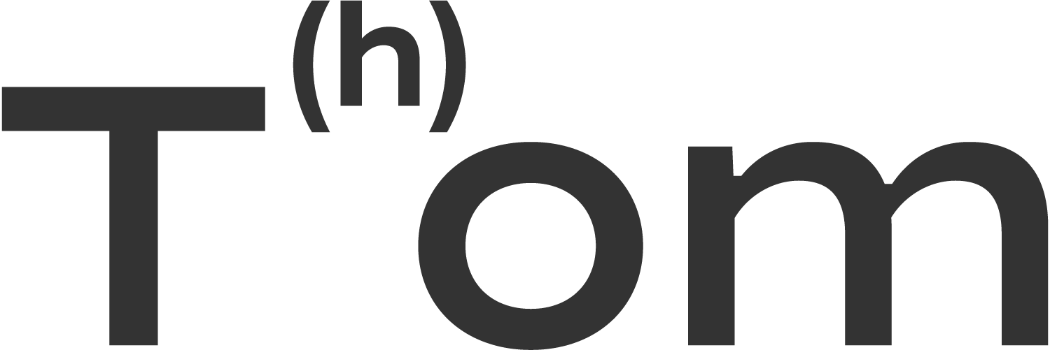 Close-up of a black and white logo that reads 'Tom' with a large letter 'T' and smaller text 'h' inside brackets.
