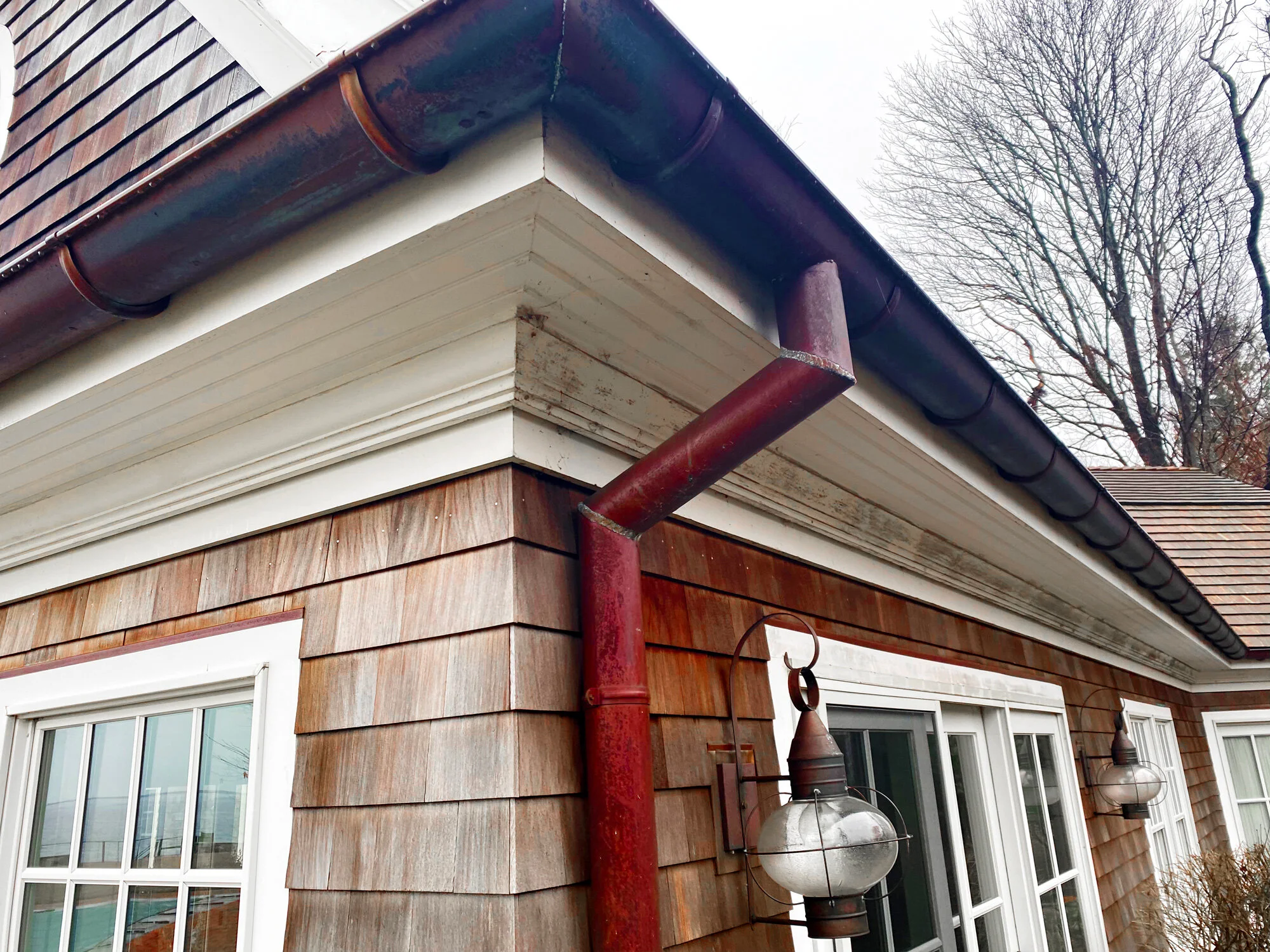 Close-up of the corner of a house with wood siding, after M & M ProWash professional soft wash exterior pressure washing in Putnam, CT.