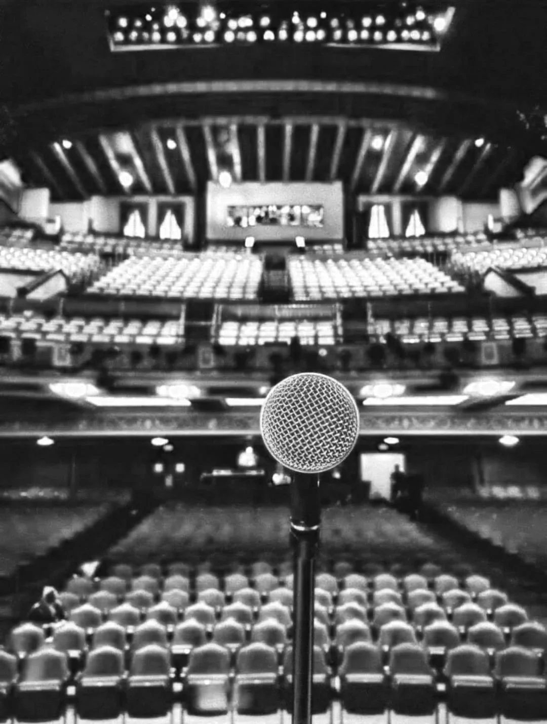 Microphone on stage in an empty theater auditorium, ready for a presentation or performance.