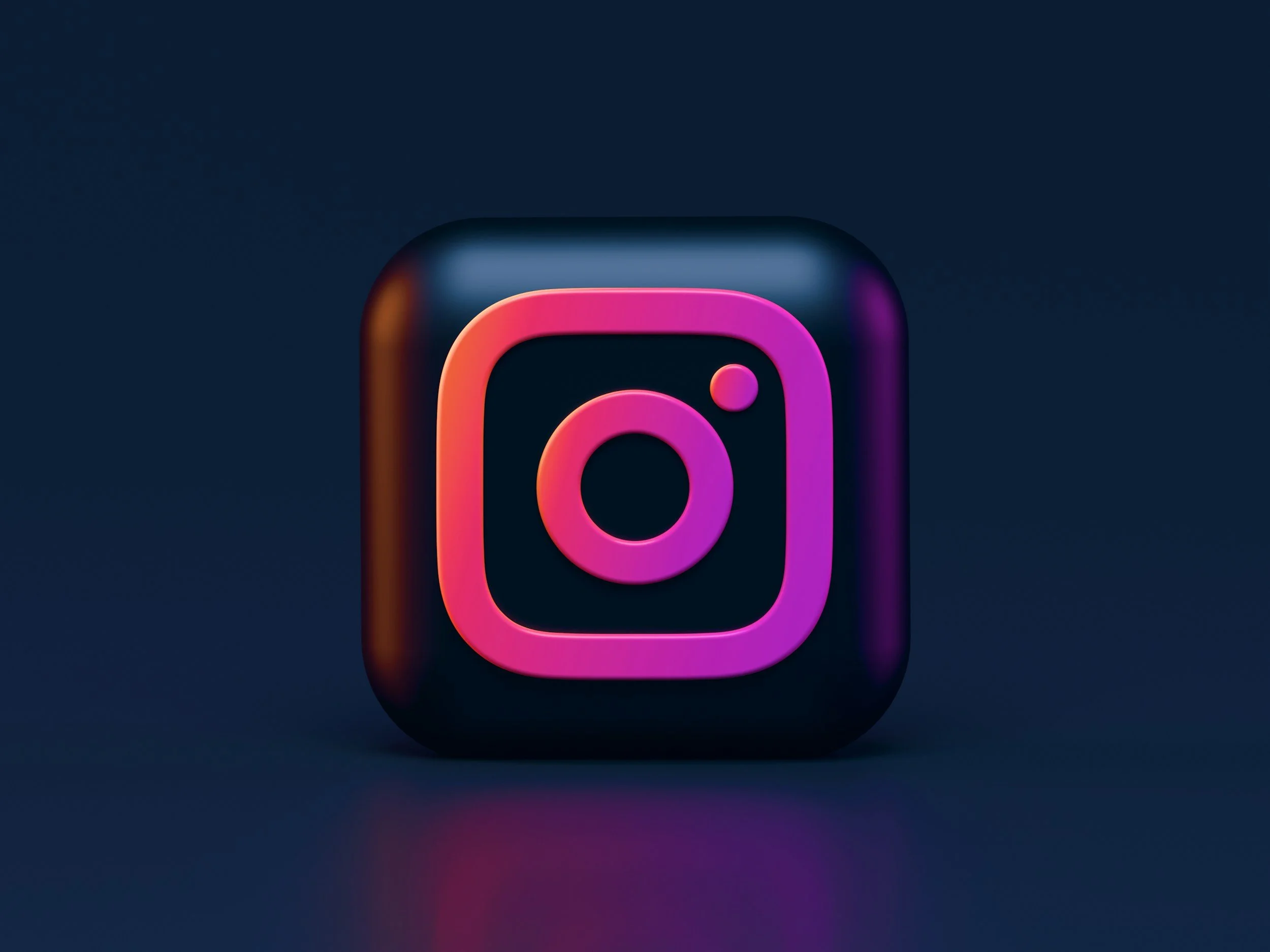 3D icon of the Instagram logo with a black background and neon pink and purple outlines.