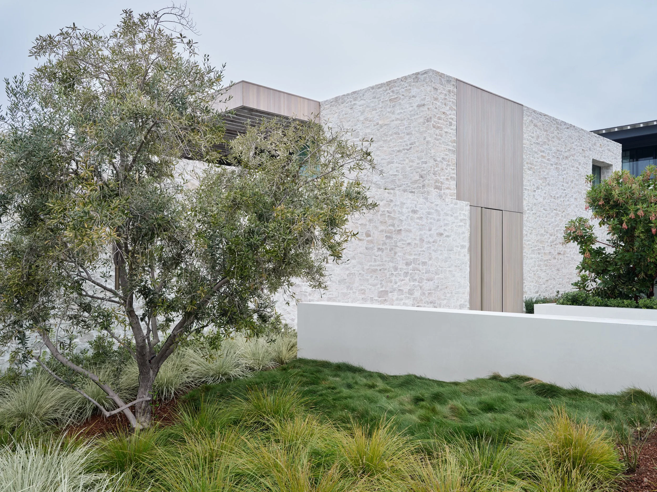 The Stone House, a California residence by Est. Collective, featuring KO Stone exterior cladding, warm wood accents, and thoughtfully landscaped grounds.