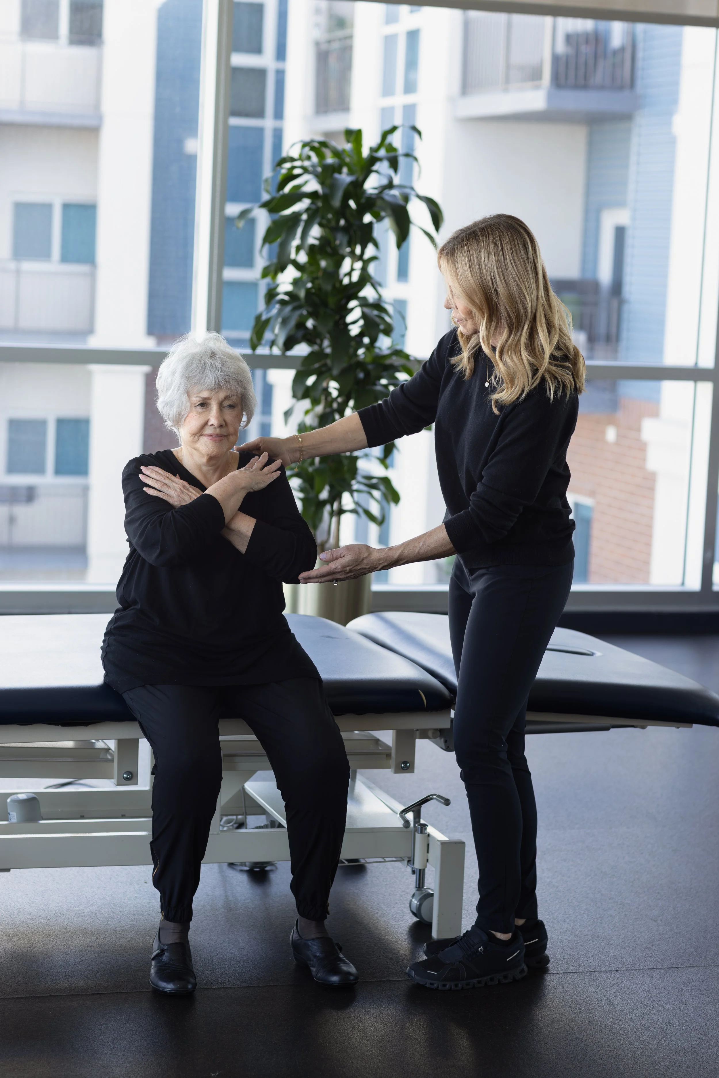 Physical therapist providing sit to stand training for elderly patient strength training