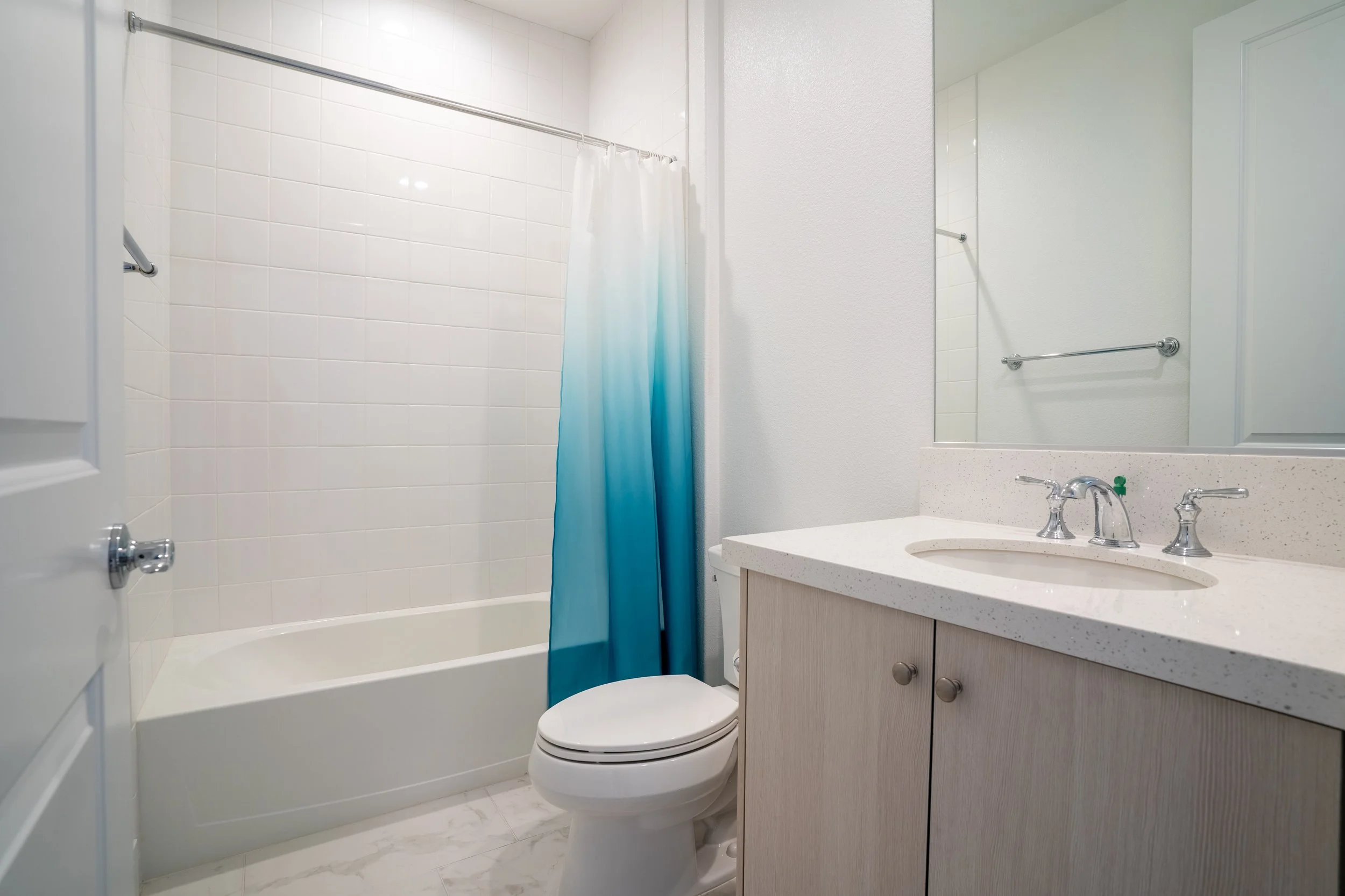 Bathroom with a bathtub and shower, toilet, and vanity with sink.
