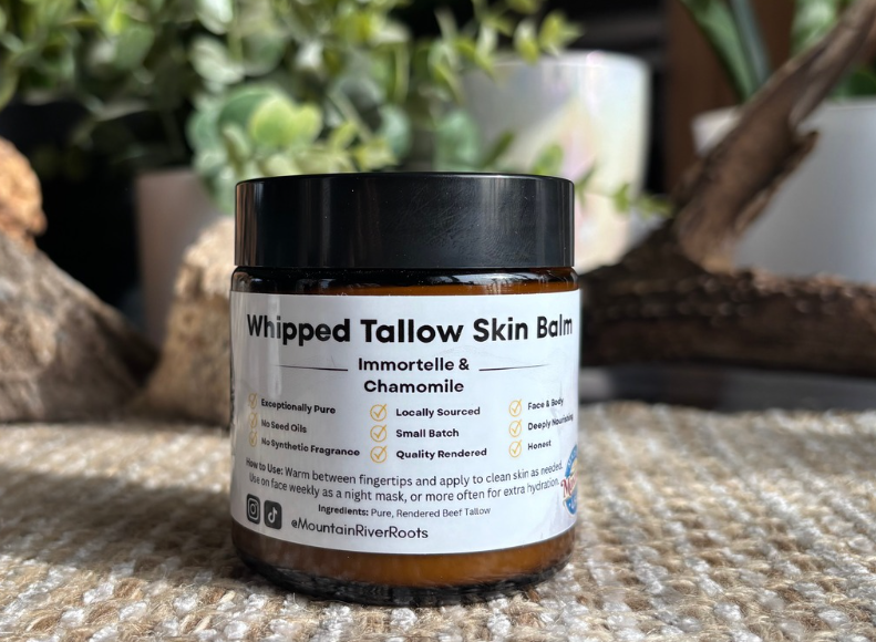 A mountain landscape with snow-capped peaks in the background, rolling grassy hills in the middle, and a modern building in the foreground.