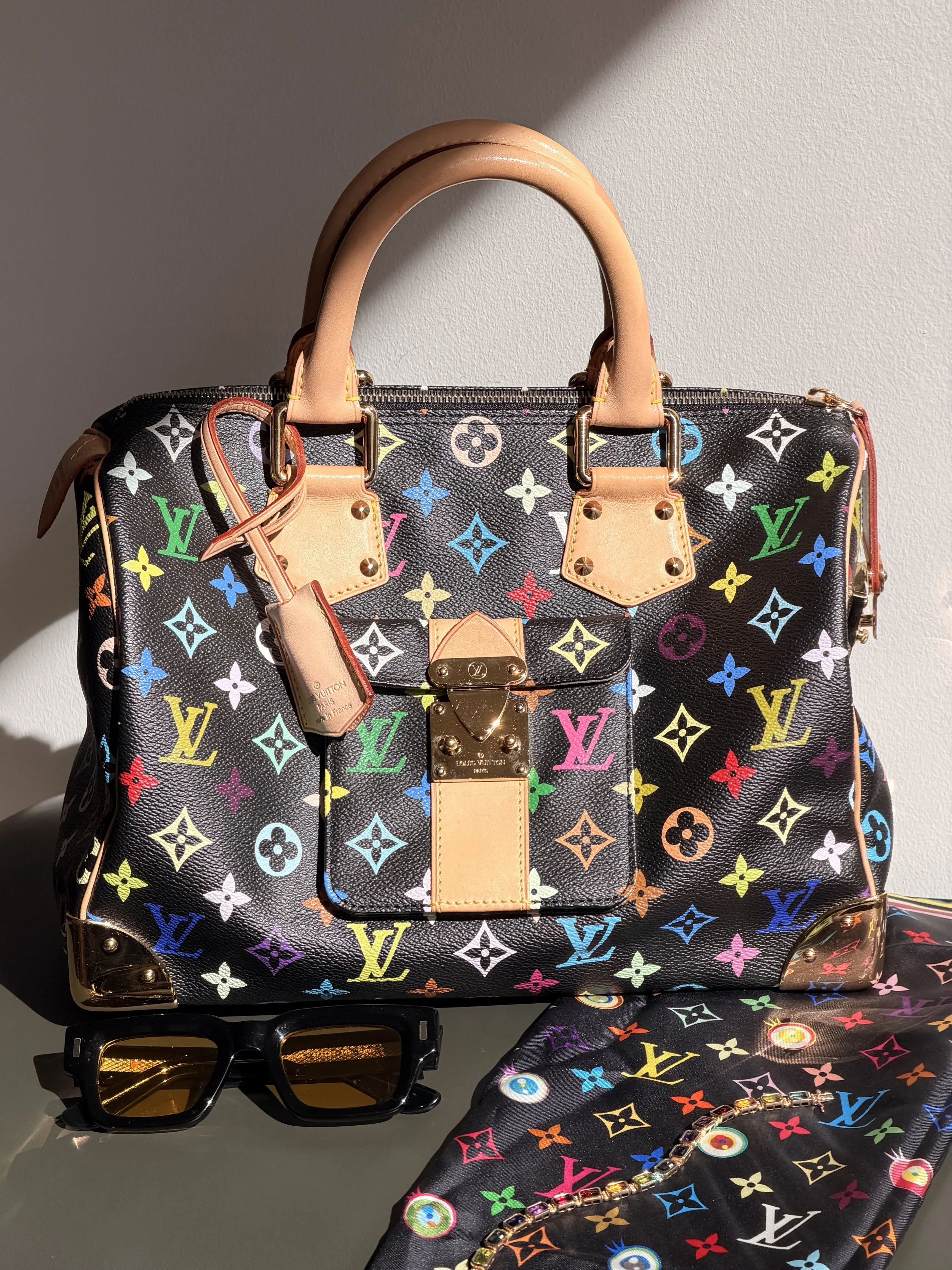 A Louis Vuitton Murakami handbag paired with multicolor accessories.