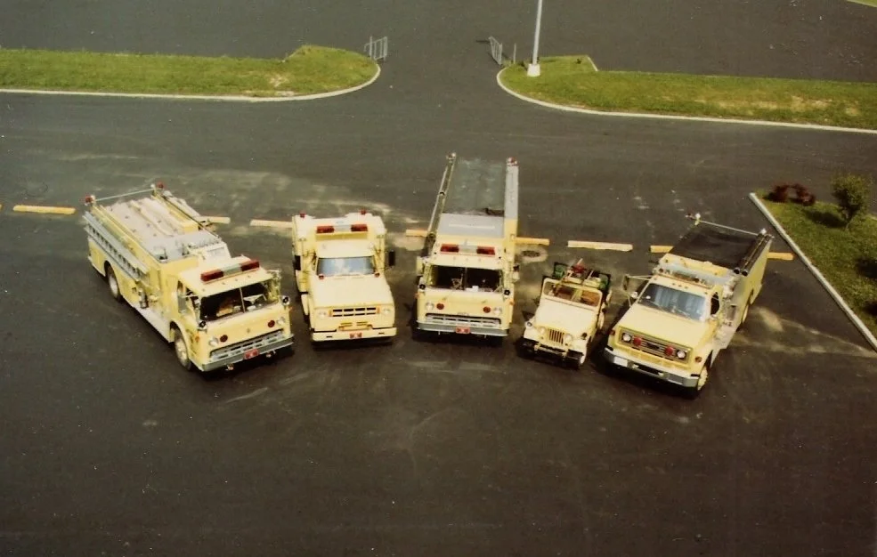 Miniature model of five parked fire trucks in a parking lot.