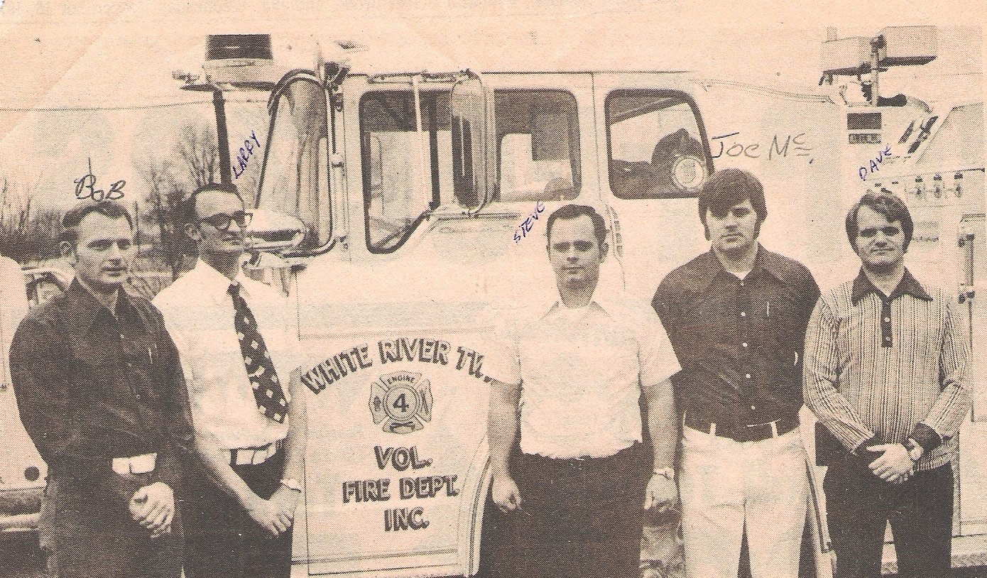 Black and white photo of five men standing in front of a fire truck with handwritten names above their heads: Bob, Larry, Steve, Joe M., and Dave. The truck has a sign reading "Choute River Twp Vol Fire Dept Inc."