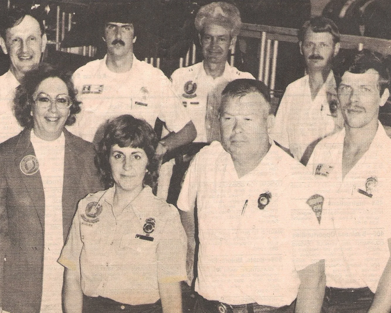 Group of eight people, including men and women, standing together, some wearing uniforms with badges. It appears to be a formal or professional gathering, possibly related to the military or emergency services.
