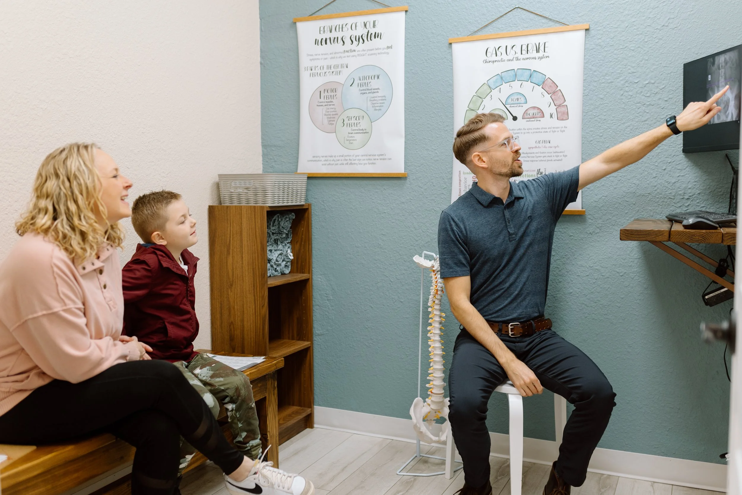 Doctor shows model of spinal column to educate family on the function of the nervous system in Gilbert, Arizona.
