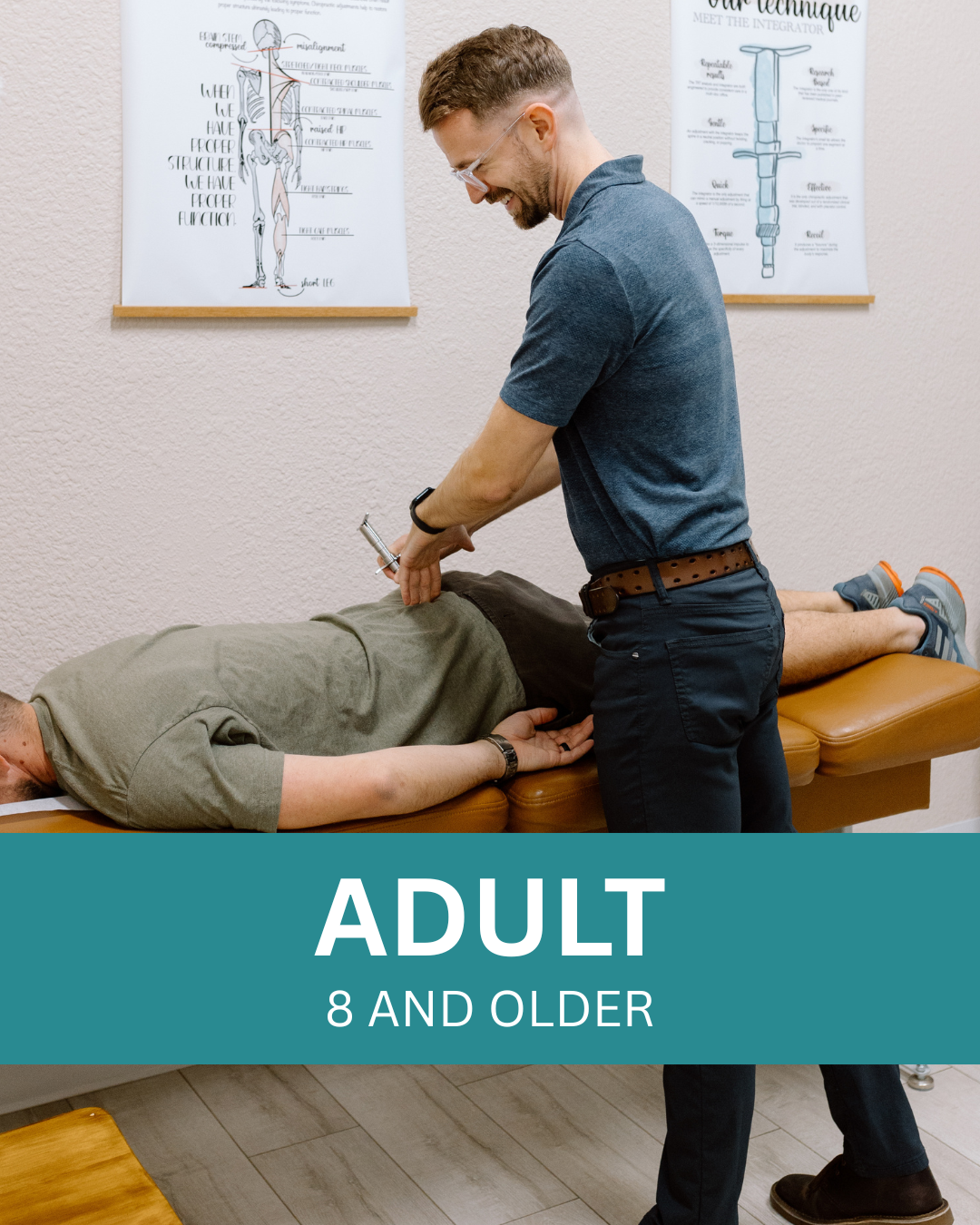 A chiropractor adjusting an adult male patient lying face down on an examination table, with anatomical posters on the wall behind them.