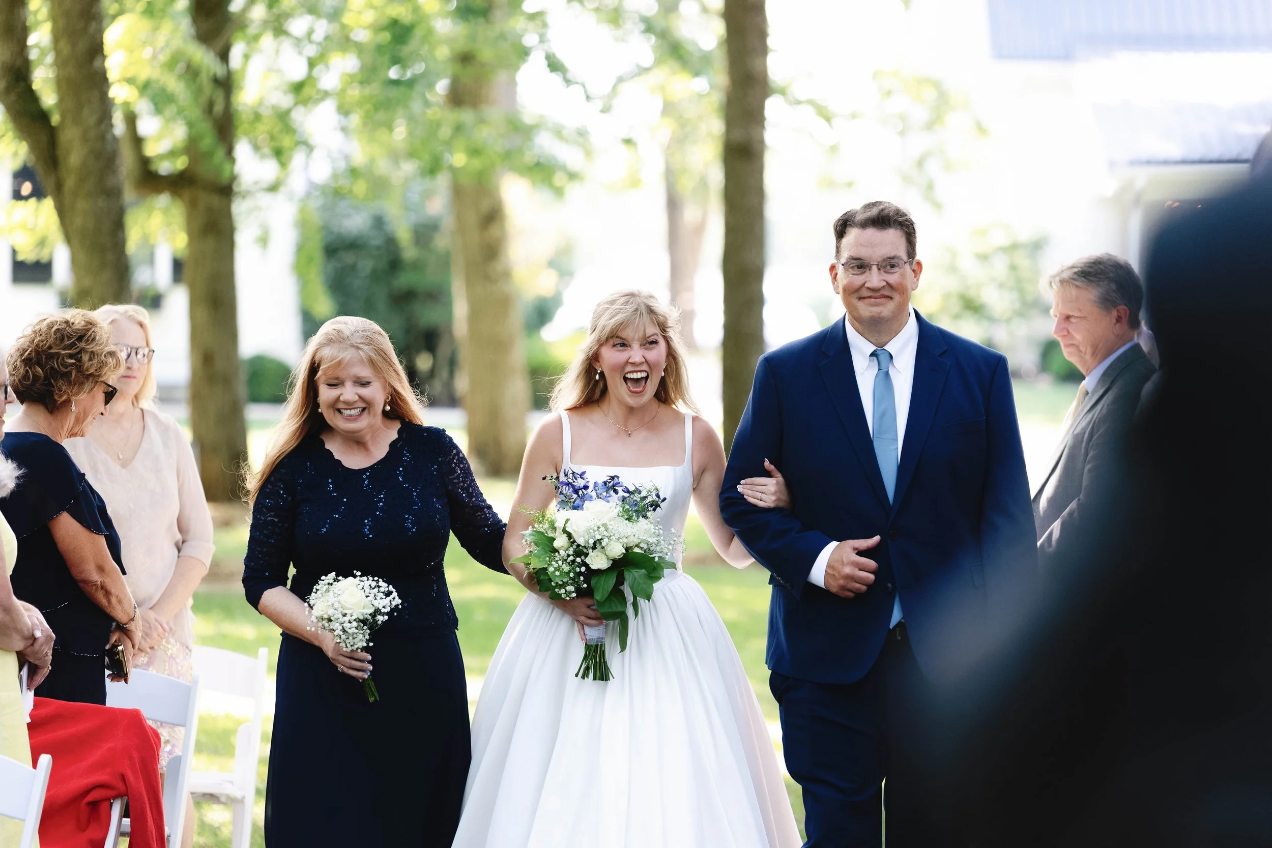 bride walking down the aisle at ashford acres inn wedding kentucky with big smile on her face 