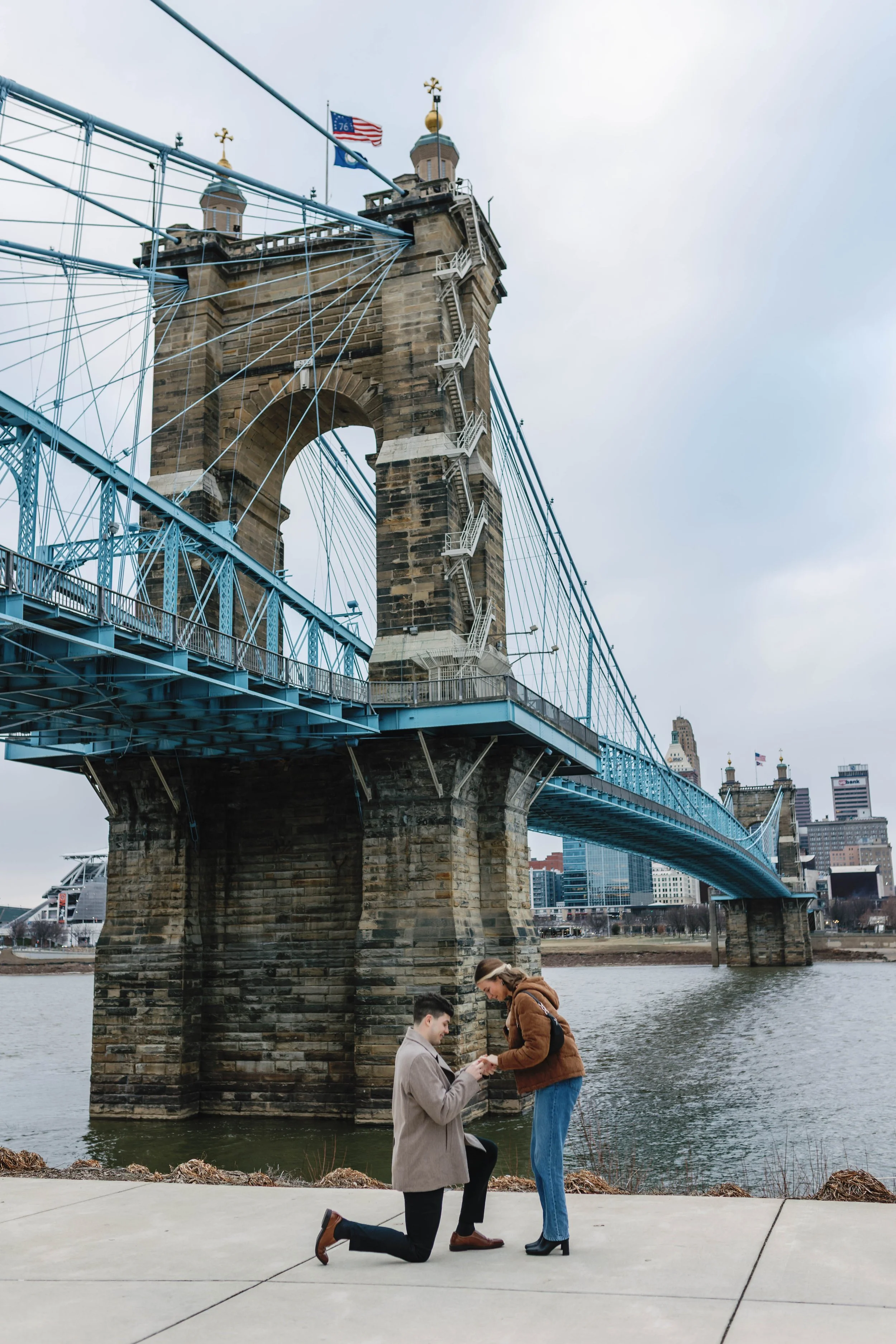 proposal at covington riverwalk with cincinnati skyline in background engagement 