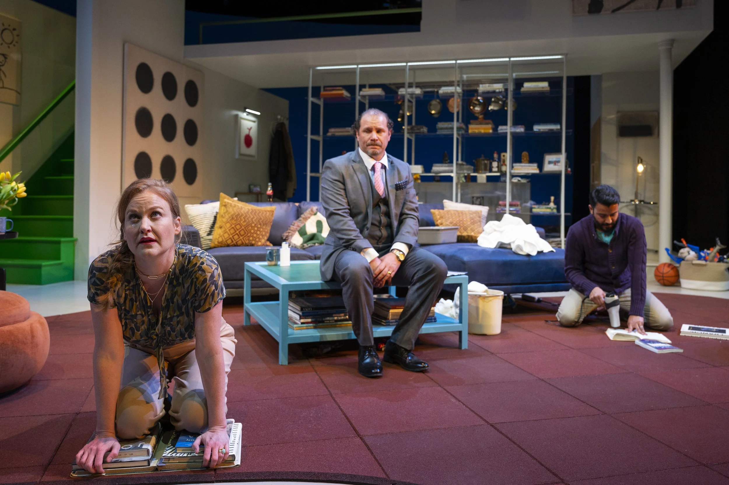 The God of Carnage hosts clean the mess off of the theatrical rug we made out of children's mats.