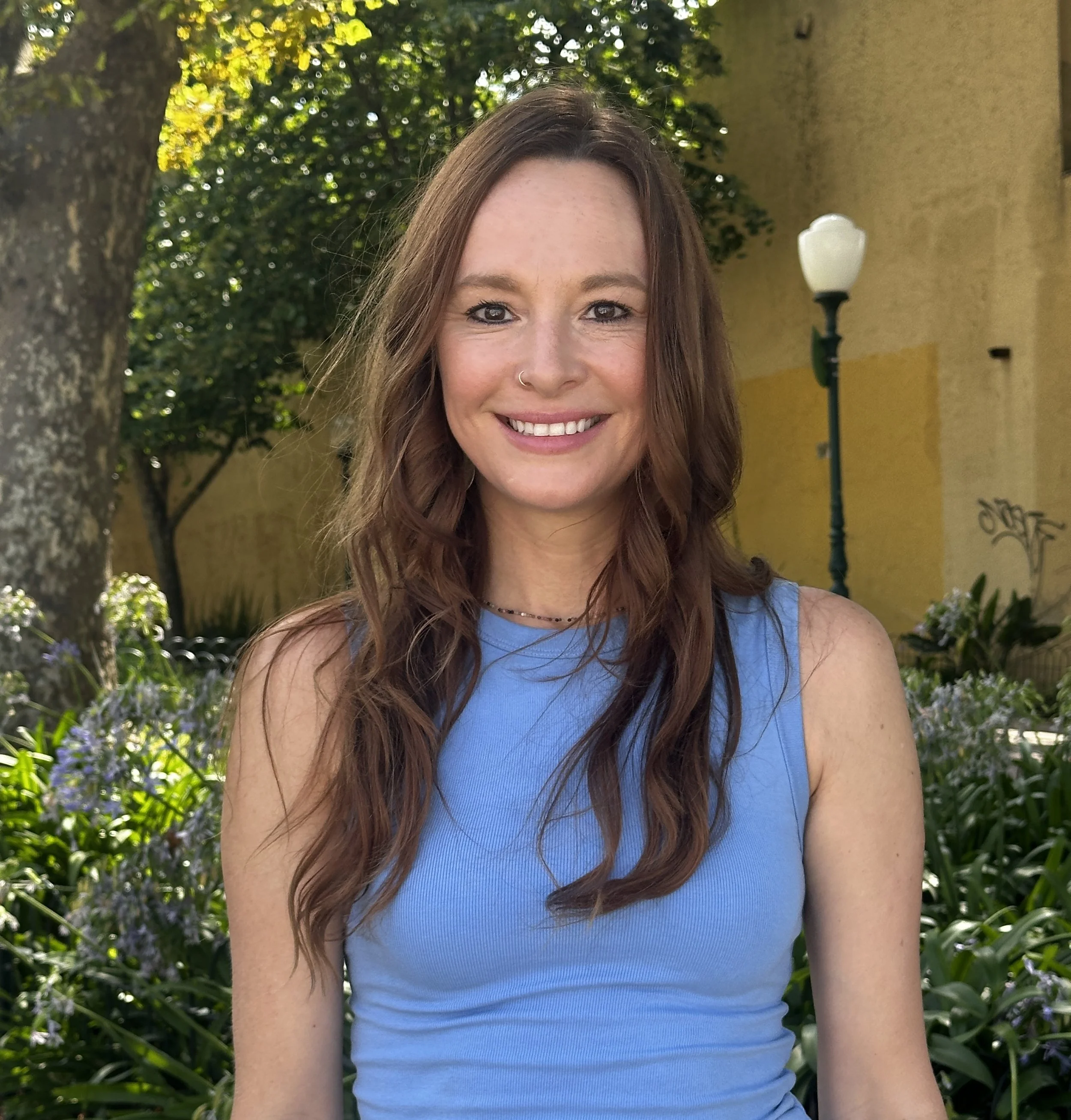 Dr. Kat Thigpen smiling outdoors surrounded by greenery